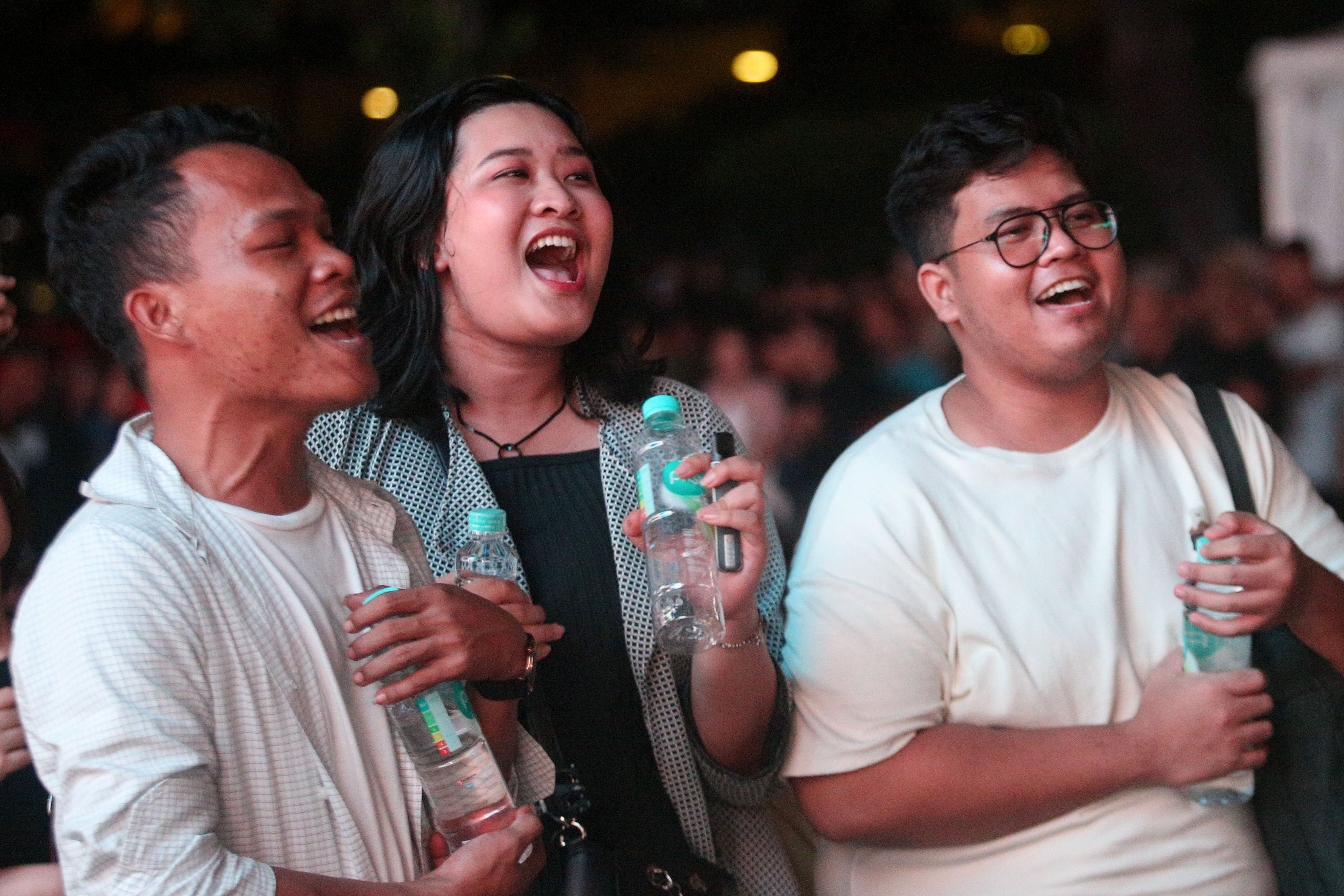 Tiga orang warga bernyanyi saat menyaksikan penampilan RAN pada acara Kirana Jakarta 2025 di Bundaran HI, Jakarta, Selasa (31/12/2024). Pemprov Jakarta menggelar perayaan malam tahun baru 2025 dengan tema Semarak Jakarta Mendunia yang diisi oleh penampilan musik dari Yura Yunita dan RAN, pertunjukkan drone hingga pesta kembang api.