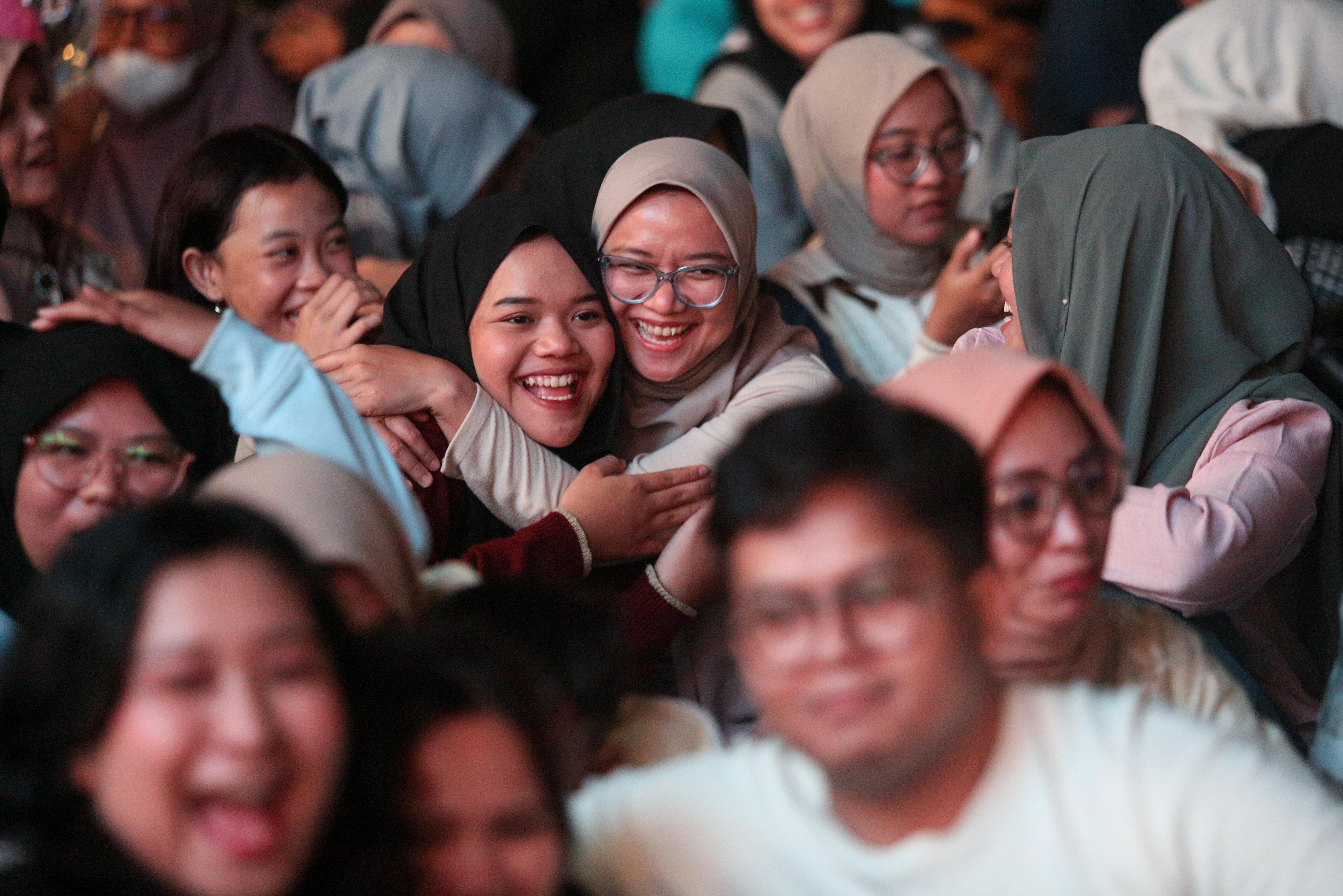 Dua orang warga berpelukan saat menyaksikan penampilan Yura Yunita pada acara Kirana Jakarta 2025 di Bundaran HI, Jakarta, Selasa (31/12/2024). Pemprov Jakarta menggelar perayaan malam tahun baru 2025 dengan tema Semarak Jakarta Mendunia yang diisi oleh penampilan musik dari Yura Yunita dan RAN, pertunjukkan drone hingga pesta kembang api.