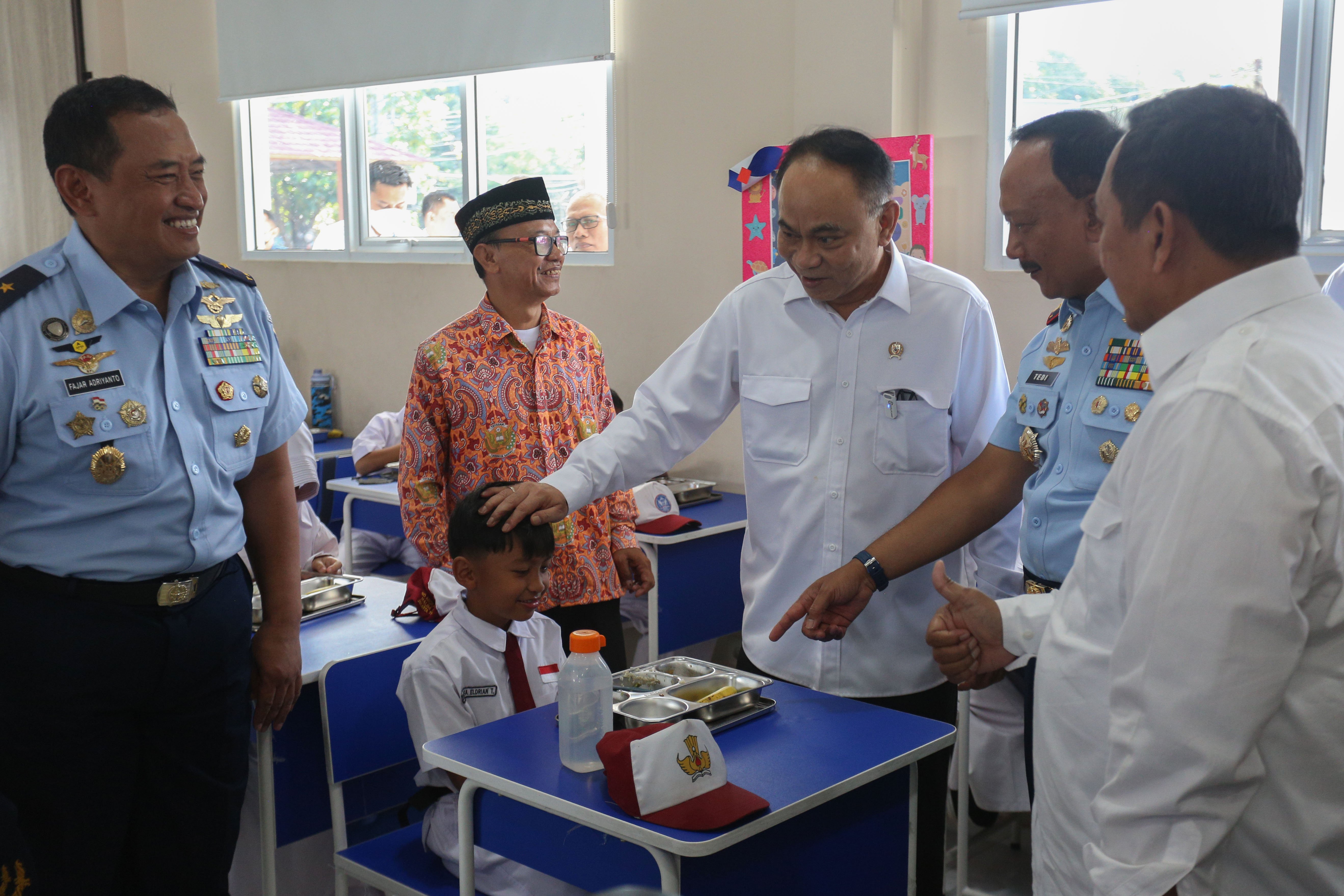 Menteri Koperasi, Budi Arie Setiadi (tengah) meninjau program makan bergizi gratis yang dilaksanakan di SD Angkasa 05 Halim Perdanakusuma, Jakarta Timur, Senin (6/1/2025). Pada hari pertama pelaksanaan Program Makan Bergizi Gratis di sekolah tersebut diikuti oleh 128 siswa dengan menu makanan yang dihidangkan yaitu nasi, tumis buncis, ayam saus teriyaki dan buah pisang.