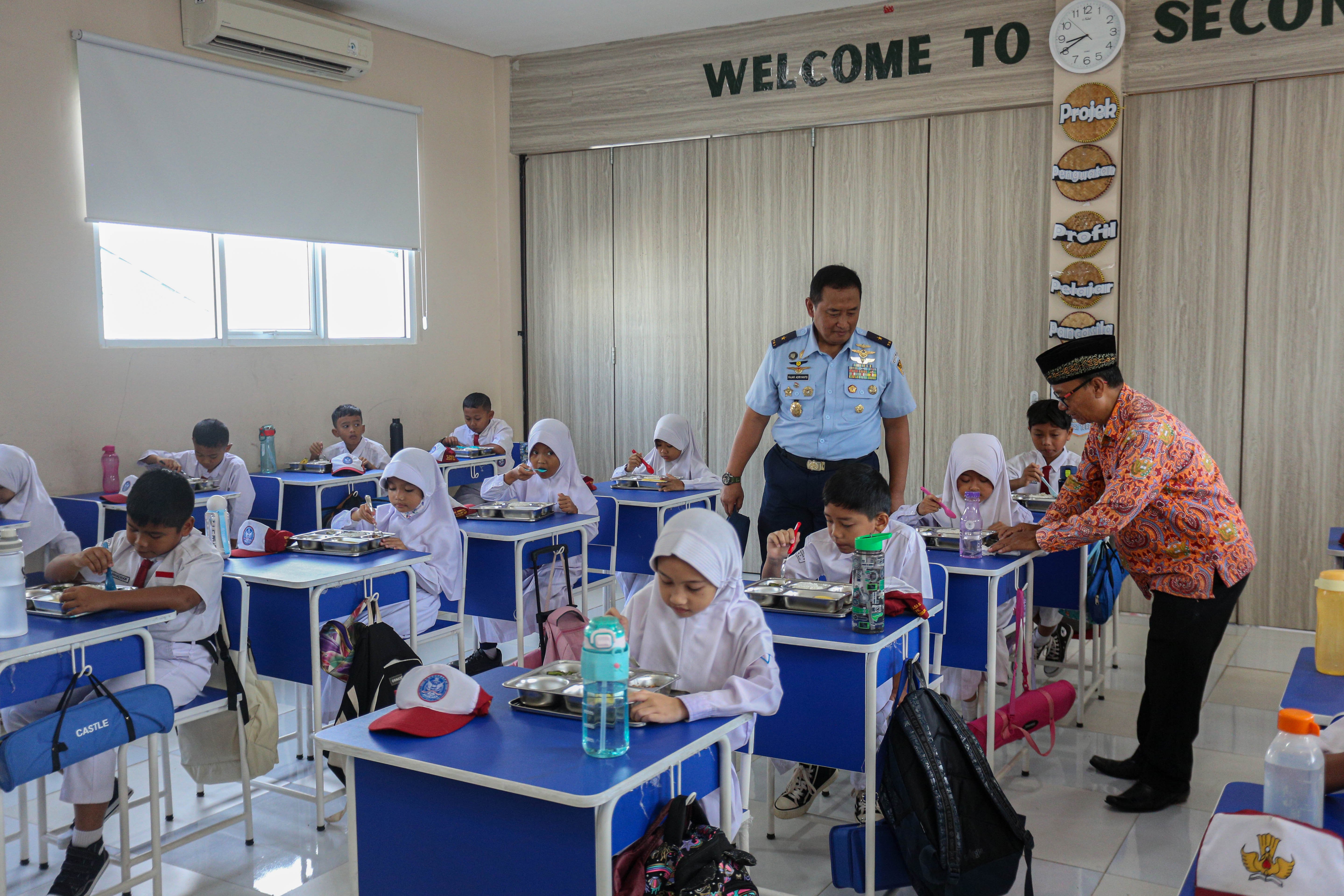 Sejumlah siswa menyantap makanan bergizi gratis di SD Angkasa 05 Halim Perdanakusuma, Jakarta Timur, Senin (6/1/2025). Pada hari pertama pelaksanaan Program Makan Bergizi Gratis di sekolah tersebut diikuti oleh 128 siswa dengan menu makanan yang dihidangkan yaitu nasi, tumis buncis, ayam saus teriyaki dan buah pisang.