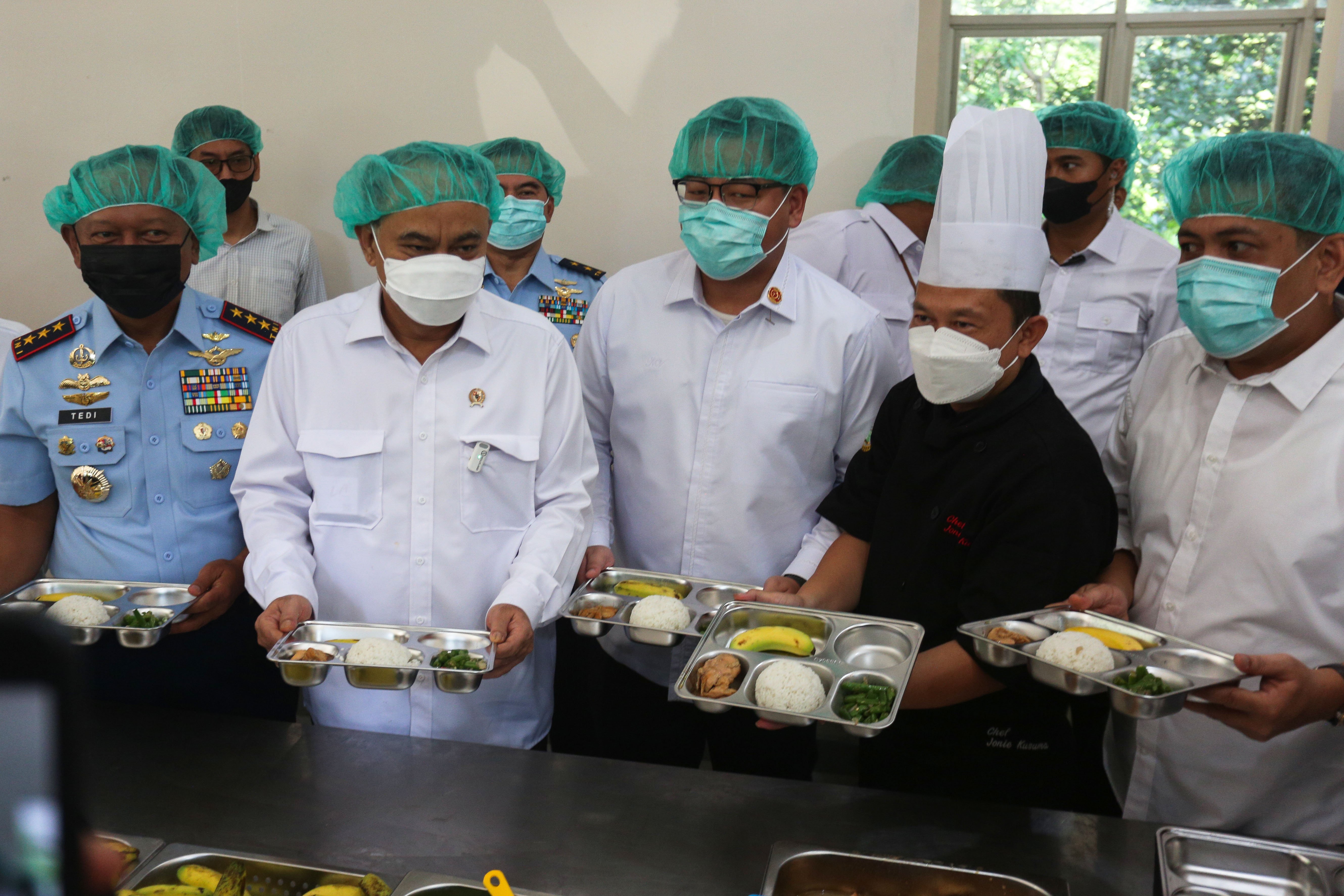 Menteri Koperasi, Budi Arie Setiadi (kedua kiri) menunjukkan paket makanan bergizi gratis di Dapur Sehat Anak Bangsa Lanud Halim Perdanakusuma, Jakarta Timur, Senin (6/1/2025). Dapur tersebut menyediakan total 2.953 paket makanan bergizi gratis untuk siswa dari berbagai tingkat pendidikan mulai dari sekolah dasar hingga menengah yang tersebar di sekitar kawasan tersebut.