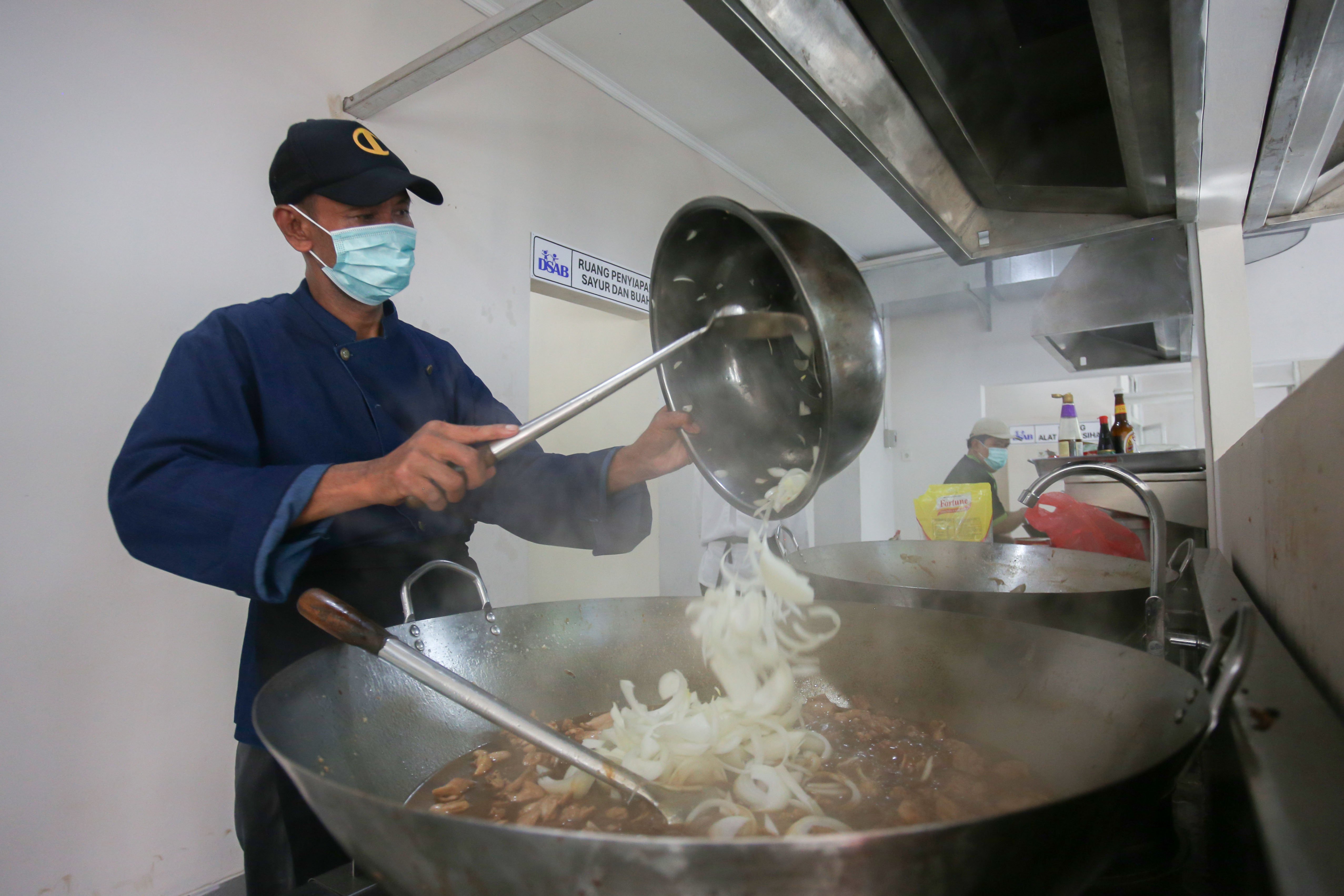 Petugas memasak makanan bergizi gratis di Dapur Sehat Anak Bangsa Lanud Halim Perdanakusuma, Jakarta Timur, Senin (6/1/2025). Dapur tersebut menyediakan total 2.953 paket makanan bergizi gratis untuk siswa dari berbagai tingkat pendidikan mulai dari sekolah dasar hingga menengah yang tersebar di sekitar kawasan tersebut.