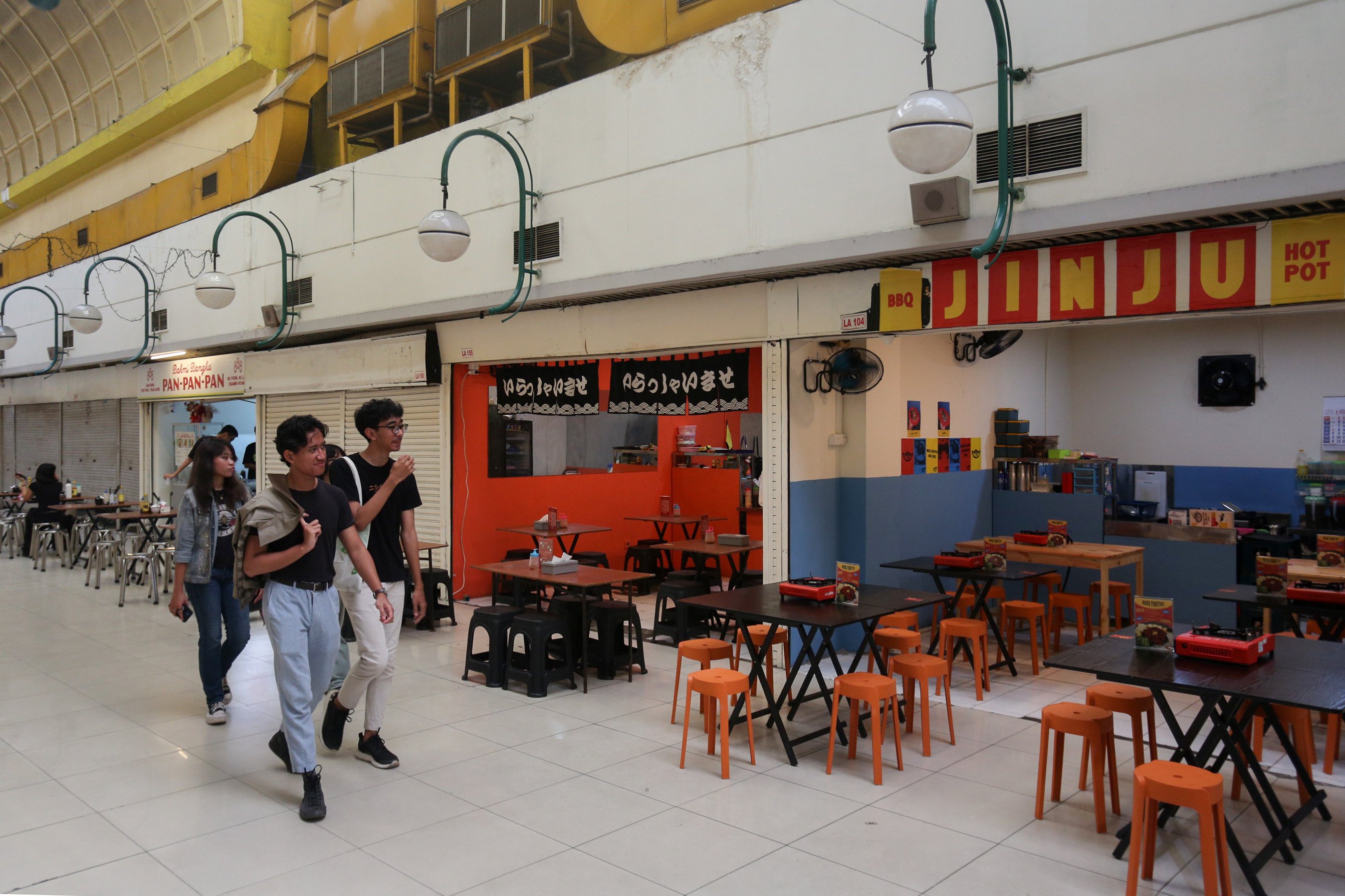 Pengunjung berjalan di dekat kios makanan di lorong bawah tanah Mal Blok M, Jakarta, Selasa (14/1/2025). Kawasan perdagangan yang sempat mati suri tersebut kini mulai kembali hidup dengan dikunjungi oleh pengunjung yang didalamnya terdapat empat kios warung makan.