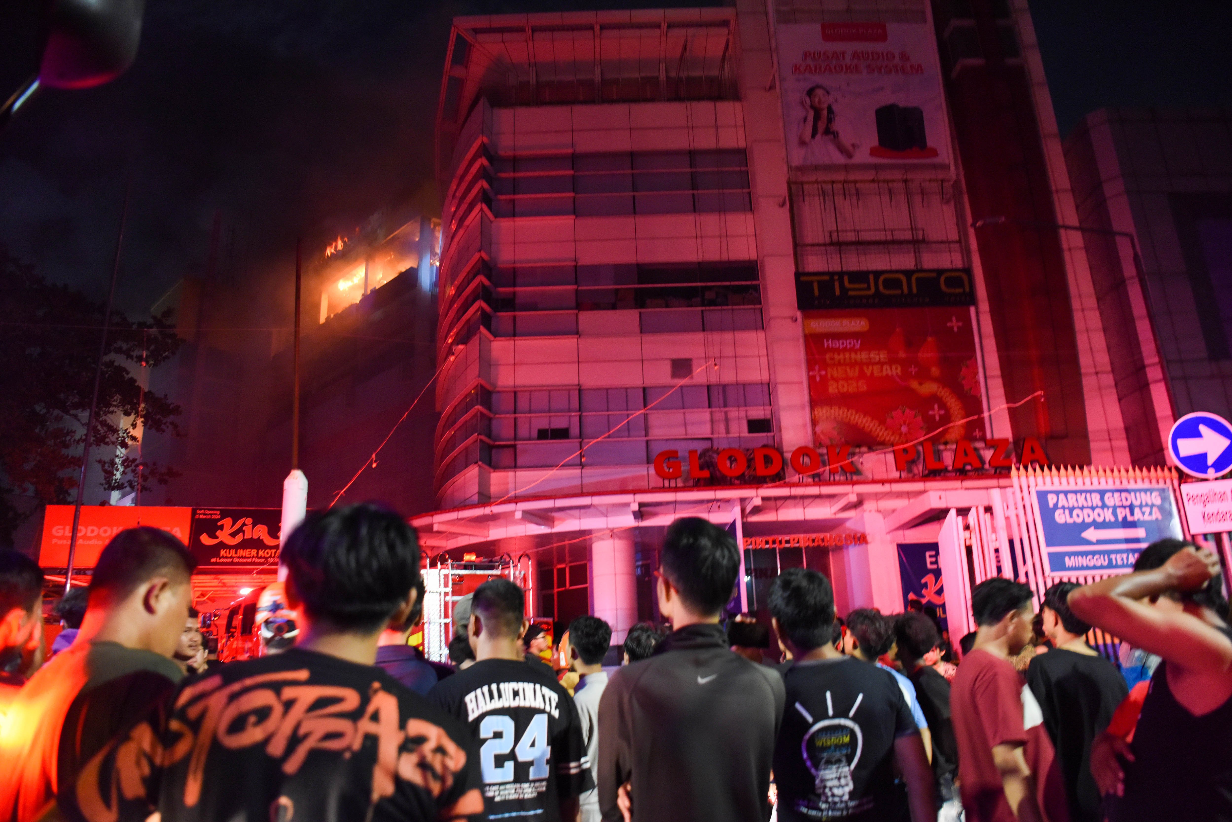 Sejumlah warga melihat kebakaran di Glodok Plaza, Taman Sari, Jakarta, Rabu (15/1/2025). Sebanyak 21 unit mobil pemadam kebakaran diterjunkan untuk memadamkan api yang masih menyala hingga Kamis (16/1) dini hari, sementara penyebab kebakaran belum diketahui. 