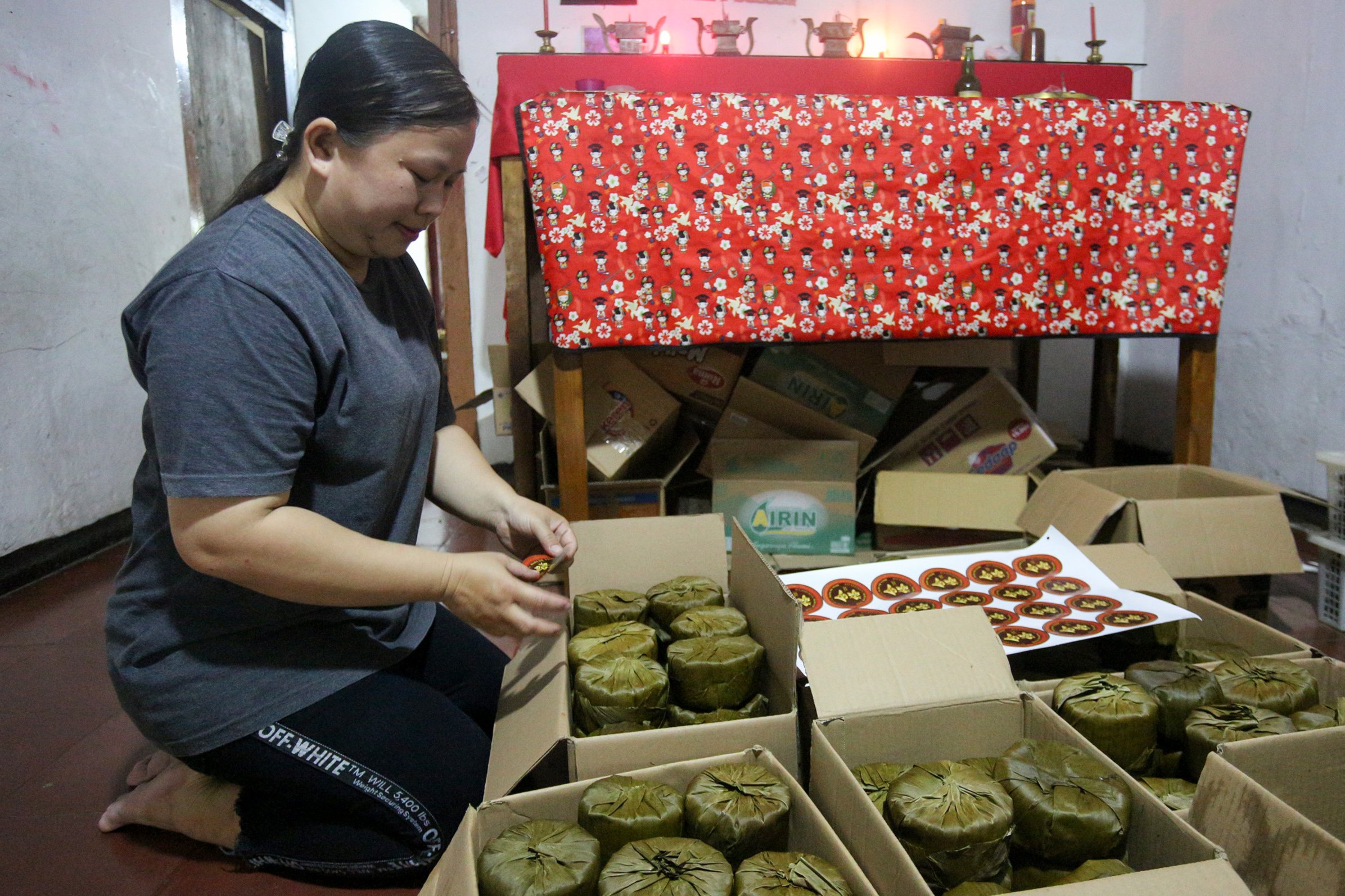 Riska (40) menata kue keranjang pesanan konsumen di rumah produksi Kue Keranjang Mama Ok Nyoh, Ciater, Kota Tangerang Selatan, Banten, Senin (20/1/2025). Menjelang Tahun Baru Imlek 2576 yang jauh pada 29 Januari 2025, produksi kue keranjang di tempat ini meningkat hingga dua kali lipat dengan total pesanan mencapai 500 kemasan per hari.