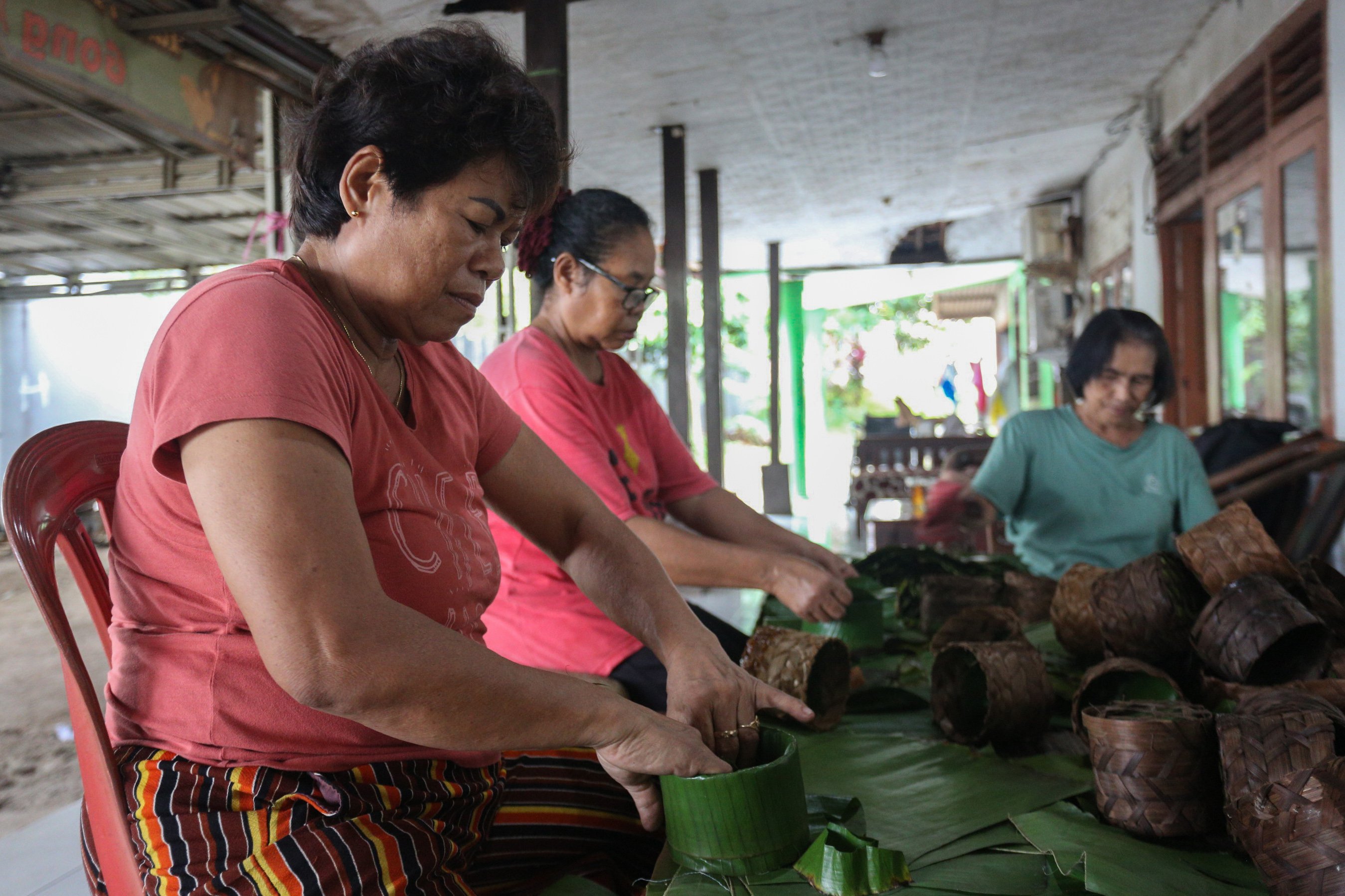 Pekerja membuat wadah kue keranjang dari bambu dan daun pisang di rumah produksi Kue Keranjang Mama Ok Nyoh, Ciater, Kota Tangerang Selatan, Banten, Senin (20/1/2025). Menjelang Tahun Baru Imlek 2576 yang jauh pada 29 Januari 2025, produksi kue keranjang di tempat ini meningkat hingga dua kali lipat dengan total pesanan mencapai 500 kemasan per hari.