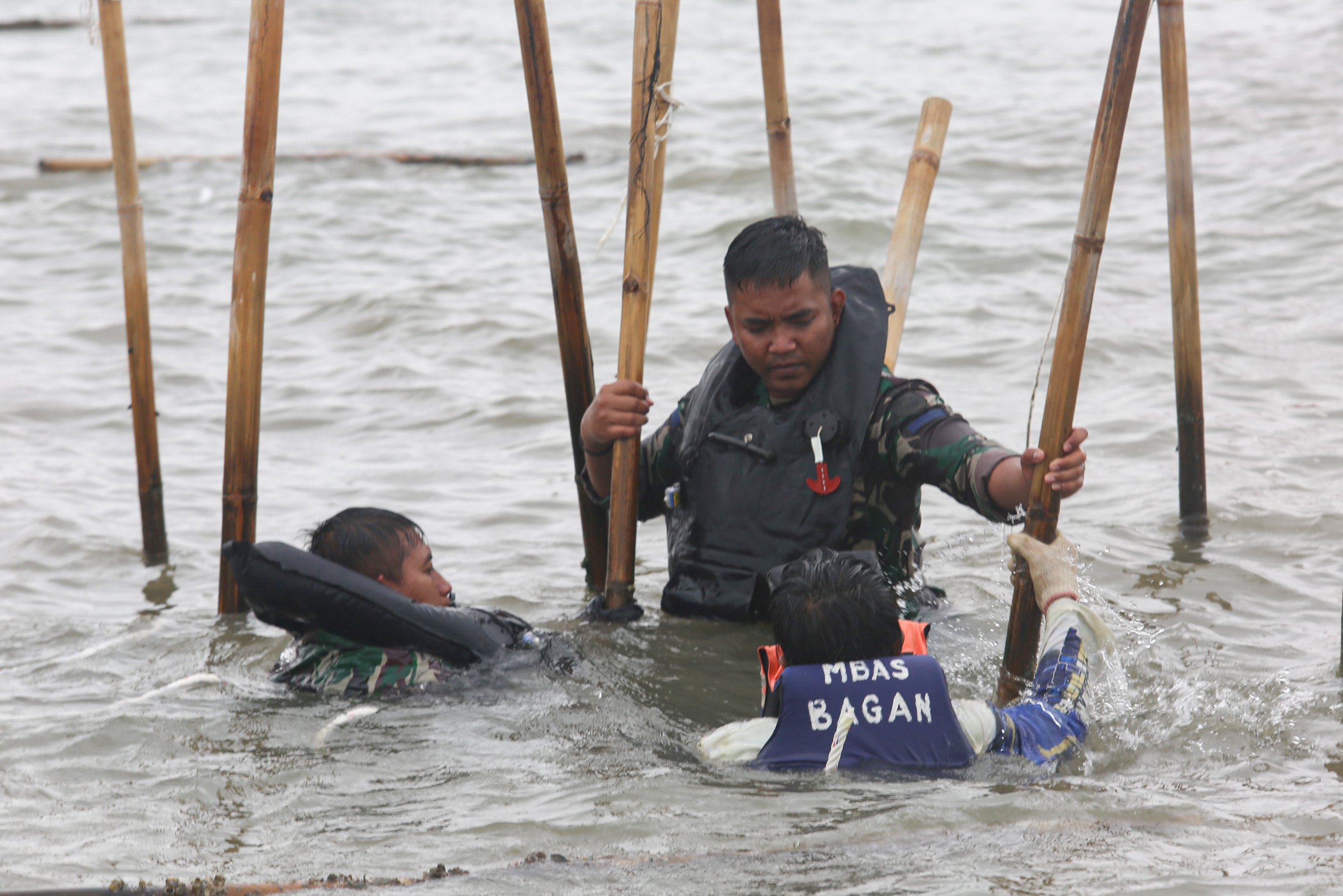 Tiga personel TNI Angkatan Laut (AL) membongkar pagar laut di kawasan Pantai Tanjung Pasir, Kabupaten Tangerang, Banten, Rabu (22/1/2025). Personel gabungan yang terdiri dari TNI AL, Kementerian Kelautan dan Perikanan (KKP) serta nelayan kembali membongkar pagar laut yang membentang sepanjang 30,16 kilometer di wilayah perairan tersebut dan ditargetkan akan selesai dalam 10 hari kedepan.