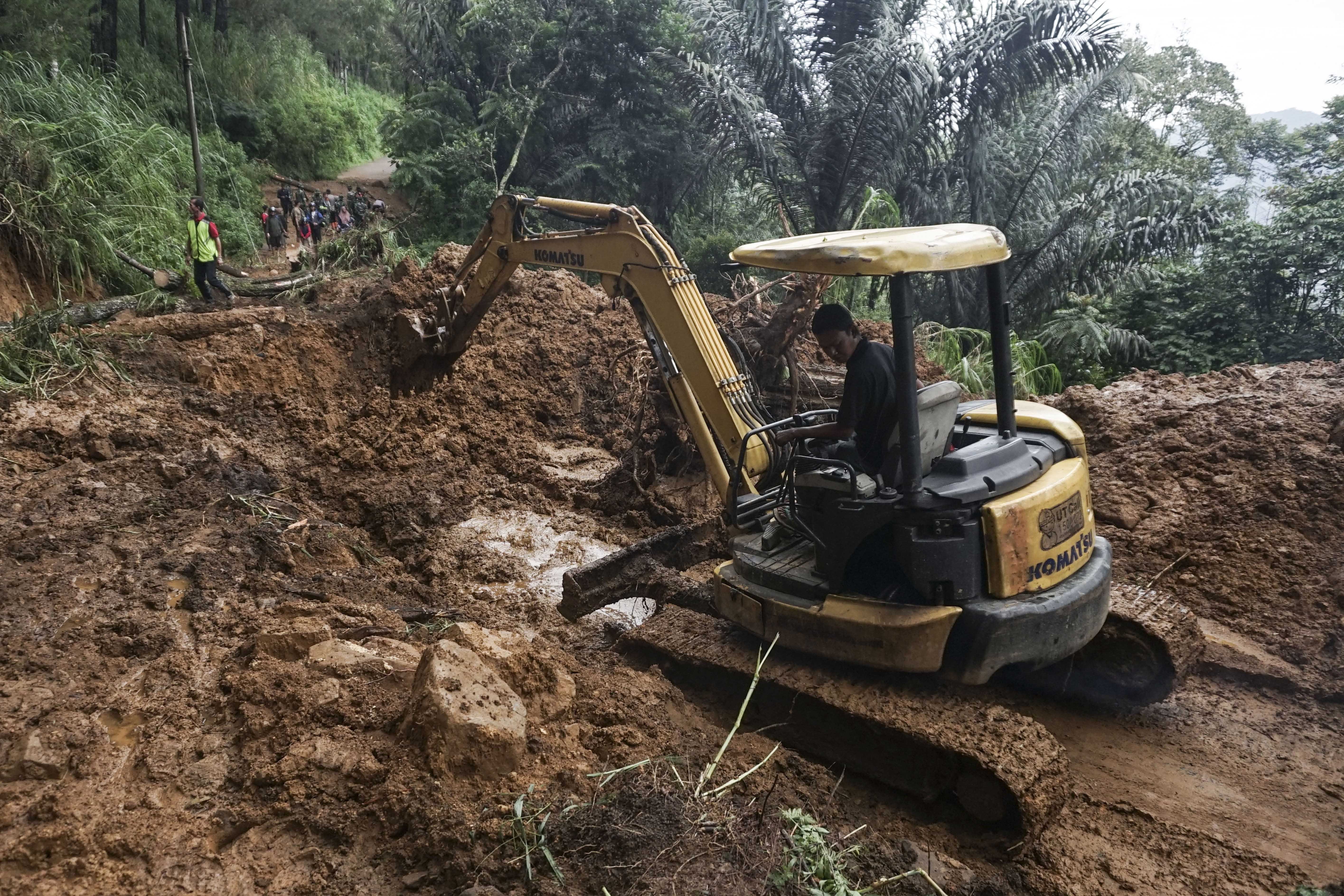 Relawan menggunakan beko untuk membersihkan lumpur di salah satu titik longsor pada hari kedua bencana longsor di Kecamatan Petungkriyono, Kabupaten Pekalongan, Jawa Tengah, Rabu (22/1/2025). Terbatasnya akses dan lokasi longsor menjadi kendala petugas serta relawan dalam memberi bantuan secara cepat.