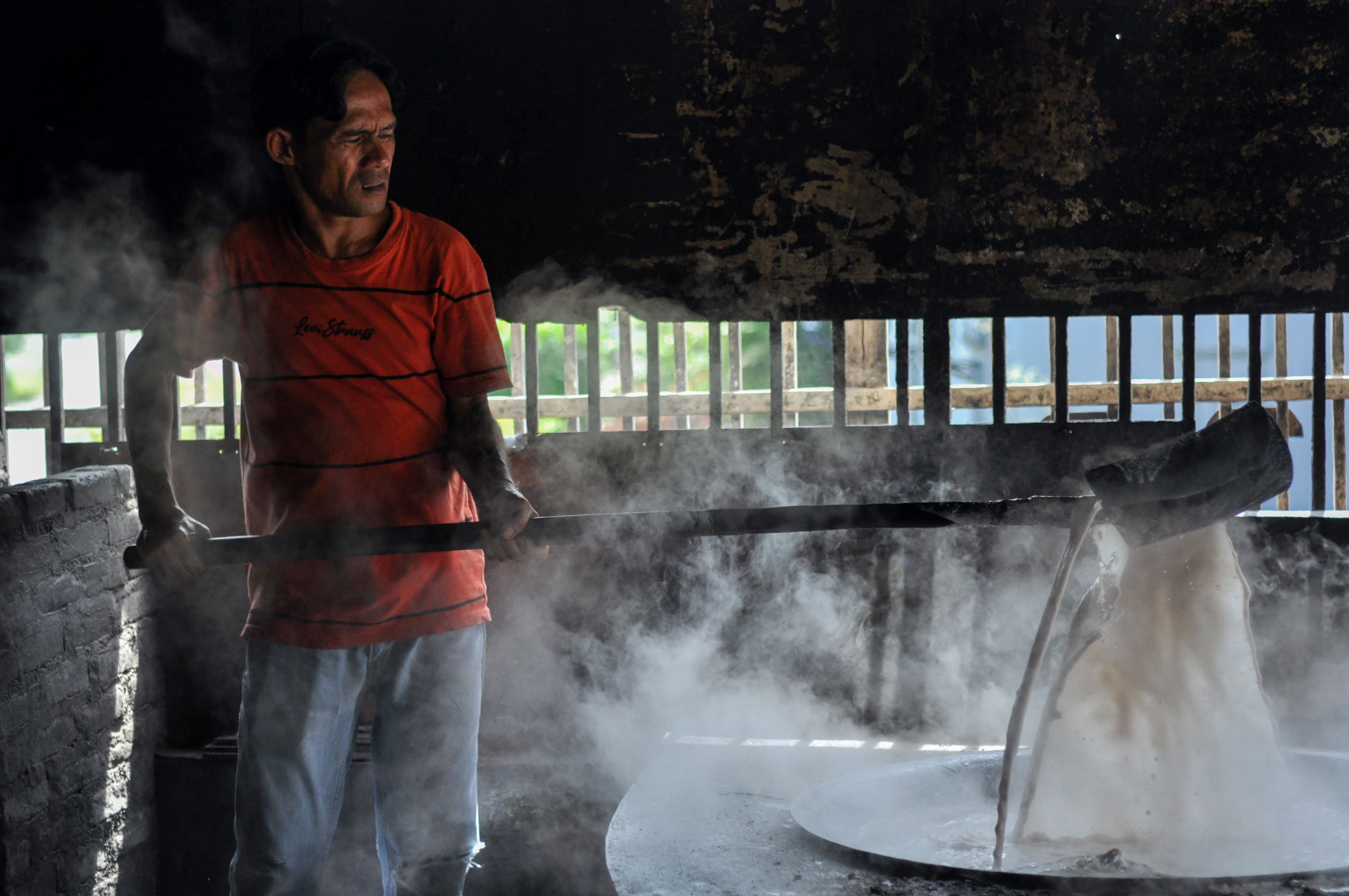Juru masak mengaduk santan untuk randang yang dimasak dengan kayu bakar selama enam jam di warung makan Rajo-rajo, Padang.
