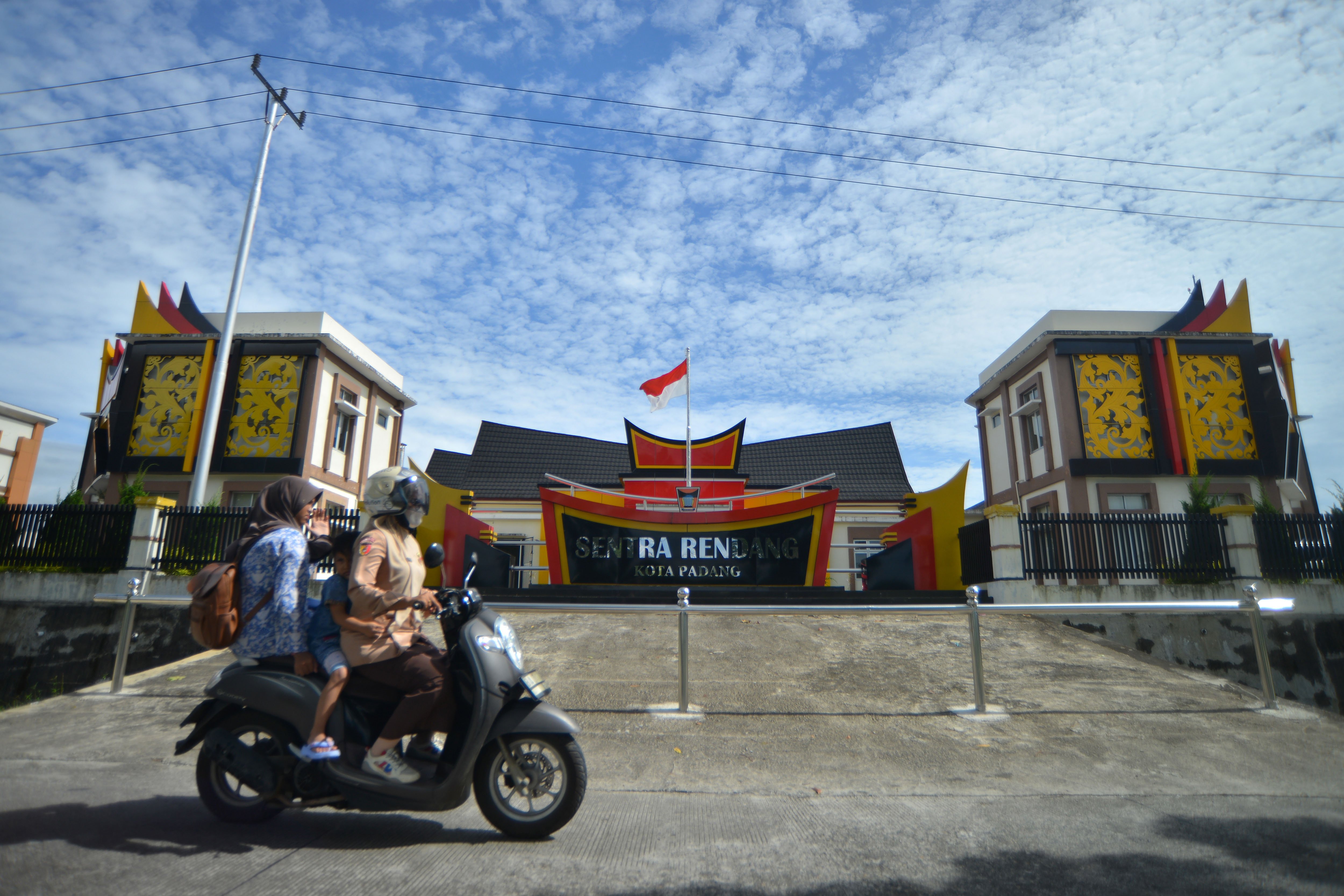 Pengendara melintas di depan gedung sentra rendang di Padang, Sumatera Barat.