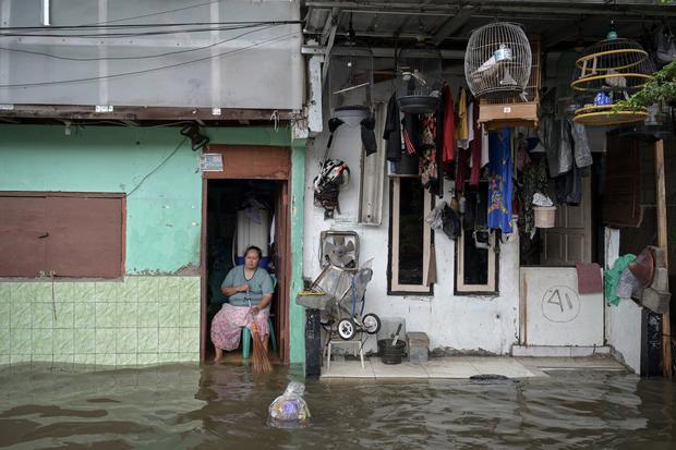 Seorang warga duduk di depan rumahnya yang terendam banjir di Rawa Terate, Cakung, Jakarta Timur, Rabu (29/1/2025). BPBD DKI Jakarta mencatat sebanyak 54 RT dan 23 ruas jalan tergenang banjir yang terjadi akibat hujan lebat di wilayah Jakarta sejak Selasa (28/1) malam.