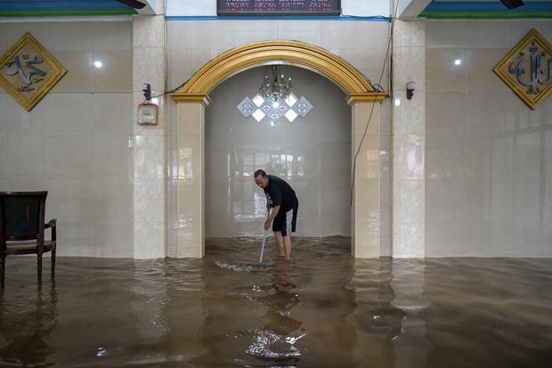 Seorang warga membersihkan ruangan masjid dari lumpur akibat banjir di Rawa Terate, Cakung, Jakarta Timur, Rabu (29/1/2025). BPBD DKI Jakarta mencatat sebanyak 54 RT dan 23 ruas jalan tergenang banjir yang terjadi akibat hujan lebat di wilayah Jakarta sejak Selasa (28/1) malam.