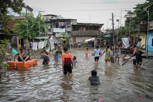 Sejumlah anak bermain di tengah banjir di Rawa Terate, Cakung, Jakarta Timur, Rabu (29/1/2025). BPBD DKI Jakarta mencatat sebanyak 54 RT dan 23 ruas jalan tergenang banjir yang terjadi akibat hujan lebat di wilayah Jakarta sejak Selasa (28/1) malam.