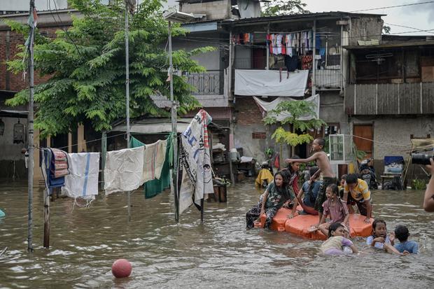 Sejumlah anak bermain di tengah banjir di Rawa Terate, Cakung, Jakarta Timur, Rabu (29/1/2025). BPBD DKI Jakarta mencatat sebanyak 54 RT dan 23 ruas jalan tergenang banjir yang terjadi akibat hujan lebat di wilayah Jakarta sejak Selasa (28/1) malam.