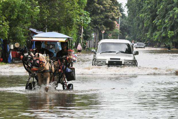 Pengendara mobil dan delman melintasi genangan air di Jalan Boulevard Barat Raya, Kelapa Gading, Jakarta Utara, Rabu (29/1/2025). BPBD DKI Jakarta menuturkan 20 ruas Jalan di Jakarta tergenang air akibat intensitas hujan yang tinggi pada (28/1) dan kualitas saluran pembuangan air ke kali yang tidak lancar.