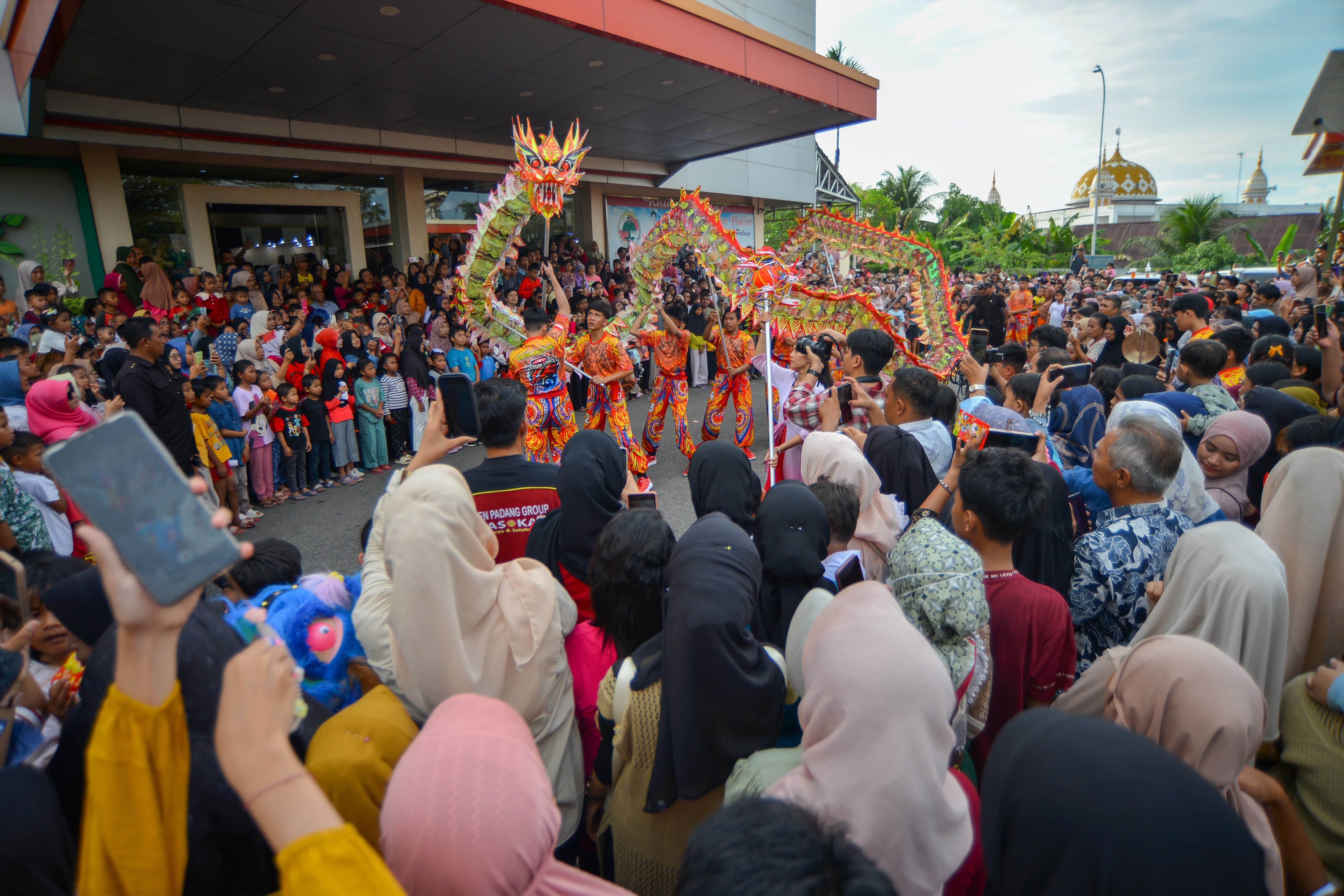 Sejumlah pengunjung menyaksikan atraksi liang-liong yang dibawakan tim HBT di Christine Hakim Idea Park (CHIP) Padang, Sumatera Barat, Rabu (29/1/2025). Atraksi barongsai dan naga memeriahkan liburan Tahun Baru Imlek 2576/2025 di objek wisata hiburan kawasan pinggiran kota tersebut.