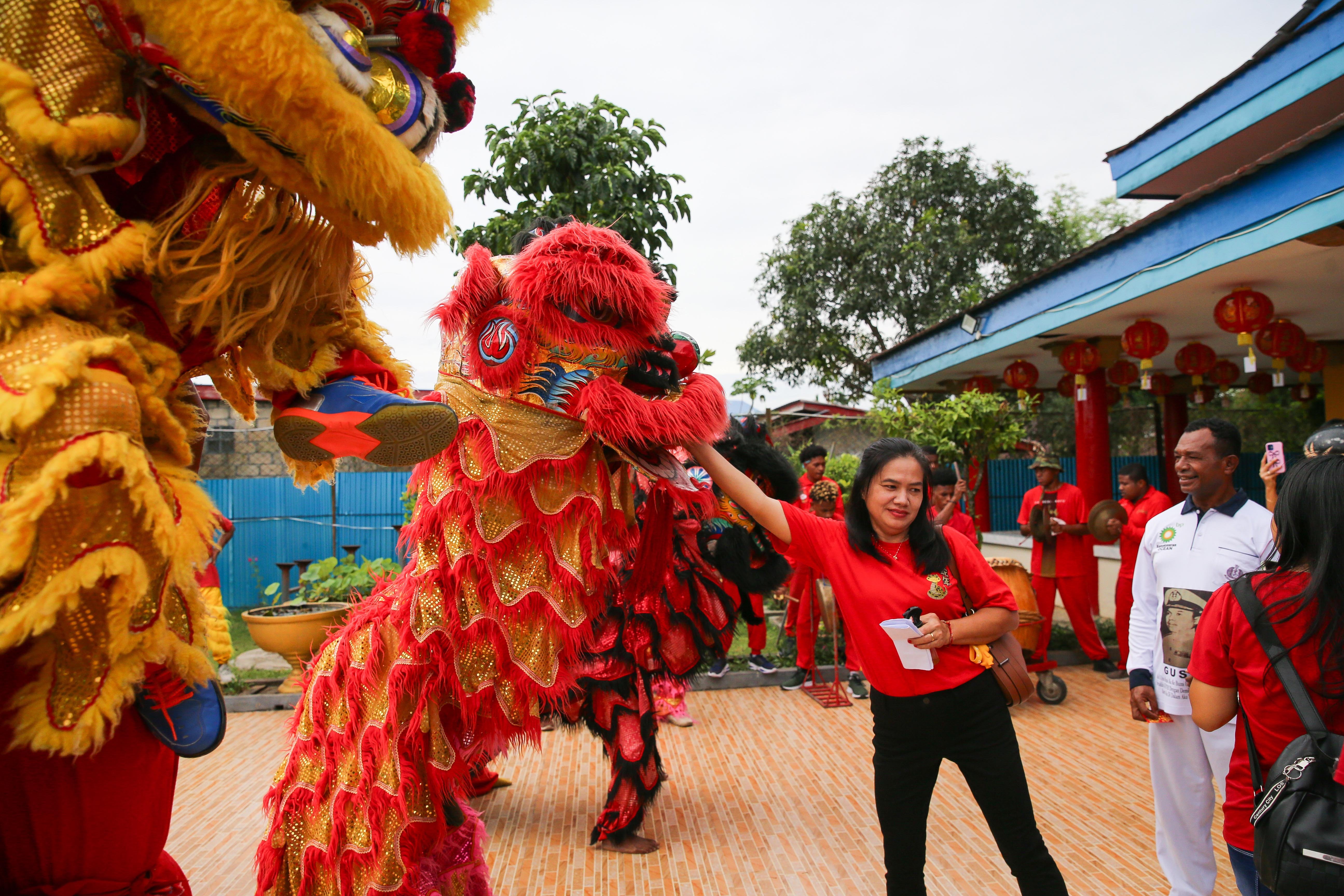 Warga memberikan angpao kepada barongsai saat melakukan atraksi di Vihara Buddha Prabha, Manokwari, Papua Barat, Rabu (29/1/2025). Pertunjukan barongsai tersebut melibatkan pemaian warga asli Papua (OAP) dalam rangka memeriahkan perayaan tahun baru Imlek 2576/2025 sekaligus menghibur warga setempat.