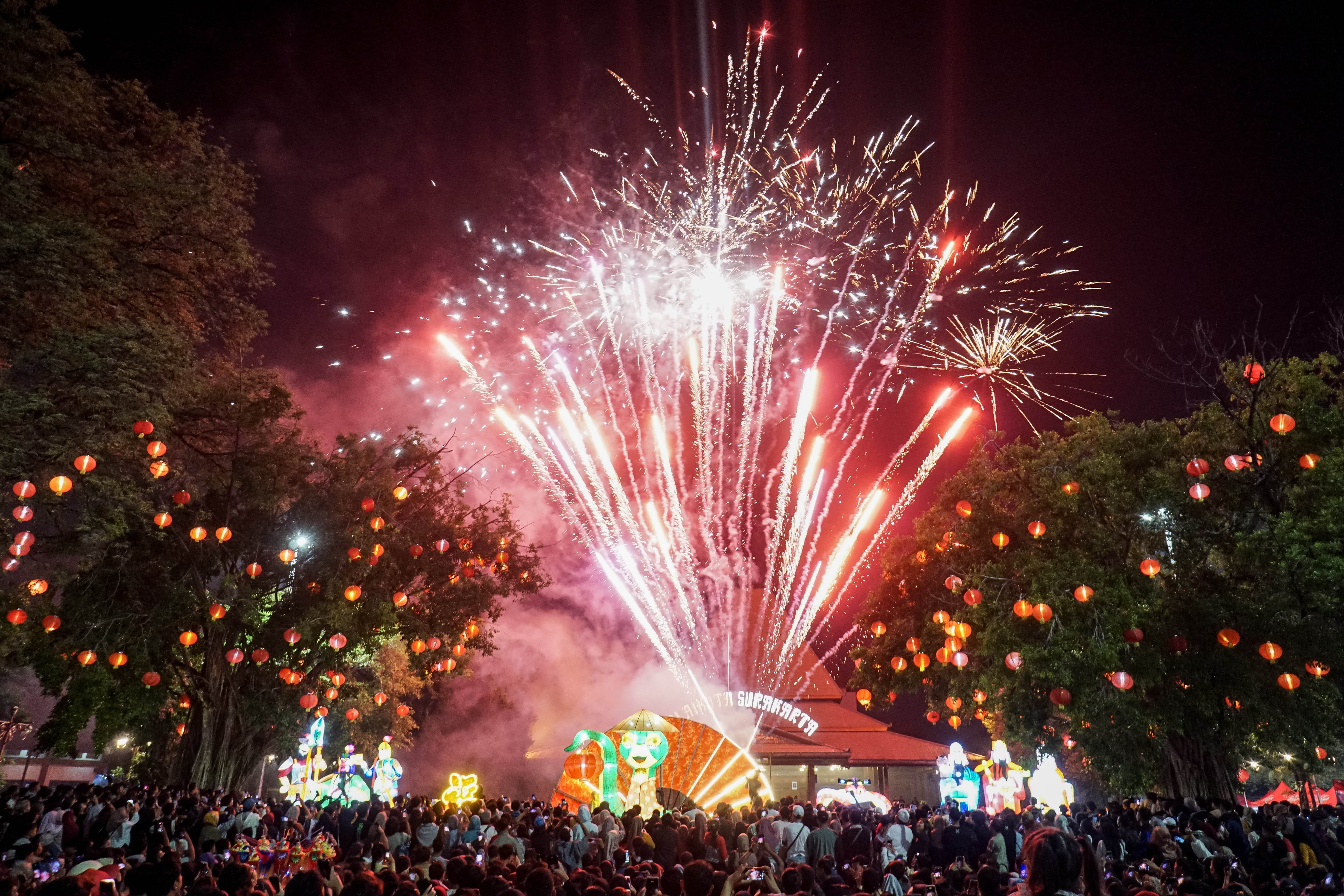 Warga menyaksikan pesta kembang api saat perayaan malam Tahun Baru Imlek di Balai Kota, Solo, Jawa Tengah, Rabu (29/1/2025) dini hari. Pesta kembang api pada perayaan Imlek tersebut sebagai tanda melepas tahun shio naga kayu sekaligus menandai datangnya tahun shio ular kayu. 