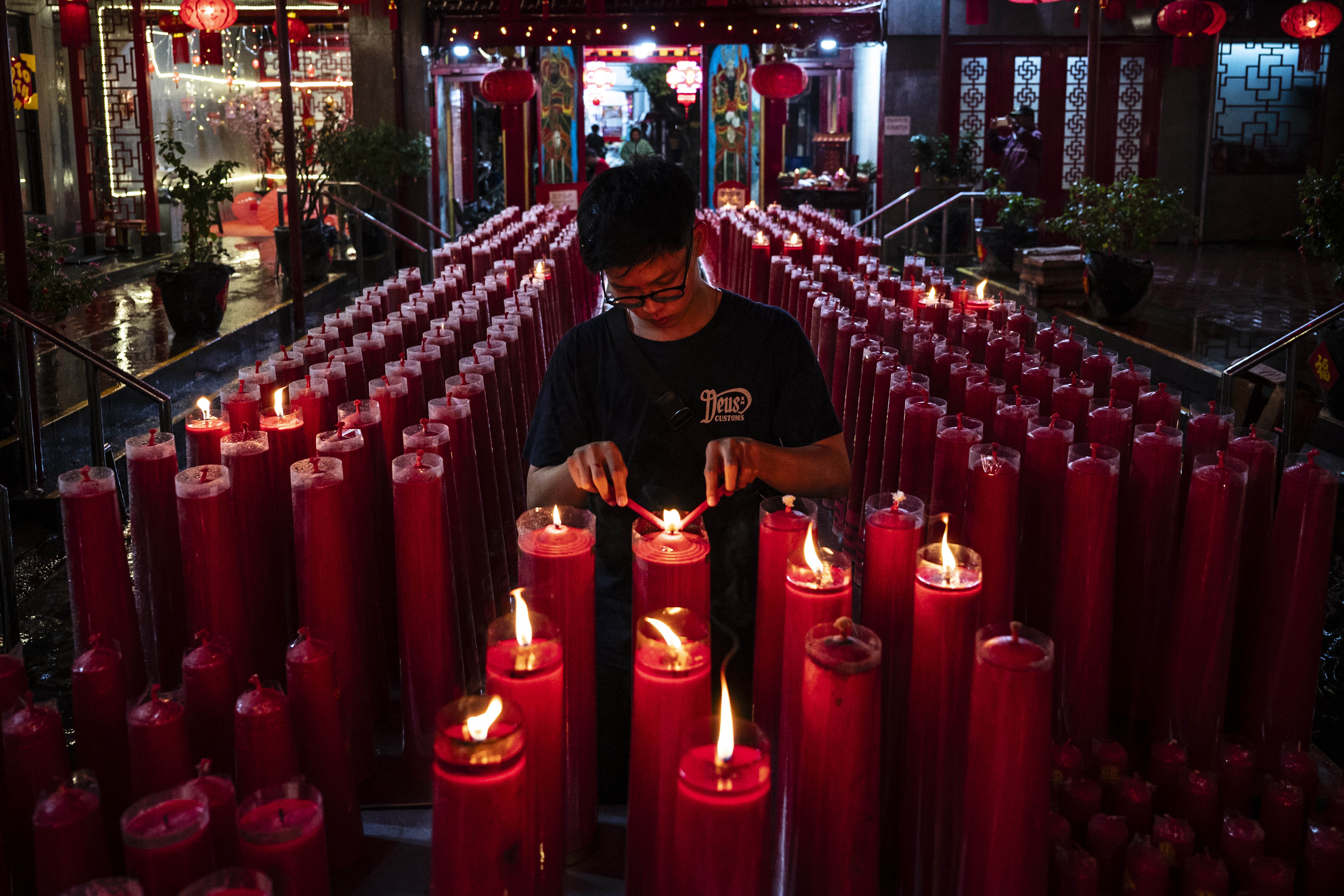Seorang warga menyalakan lilin saat sembahyang malam pergantian Tahun Baru Imlek 2576/2025 di Kelenteng Tao Se Bio, Petak Sembilan, Jakarta, Selasa (28/1/2025). Warga Tionghoa berdoa di kelenteng untuk merayakan pergantian tahun baru Imlek yang bertepatan dengan tahun Ular Kayu. 