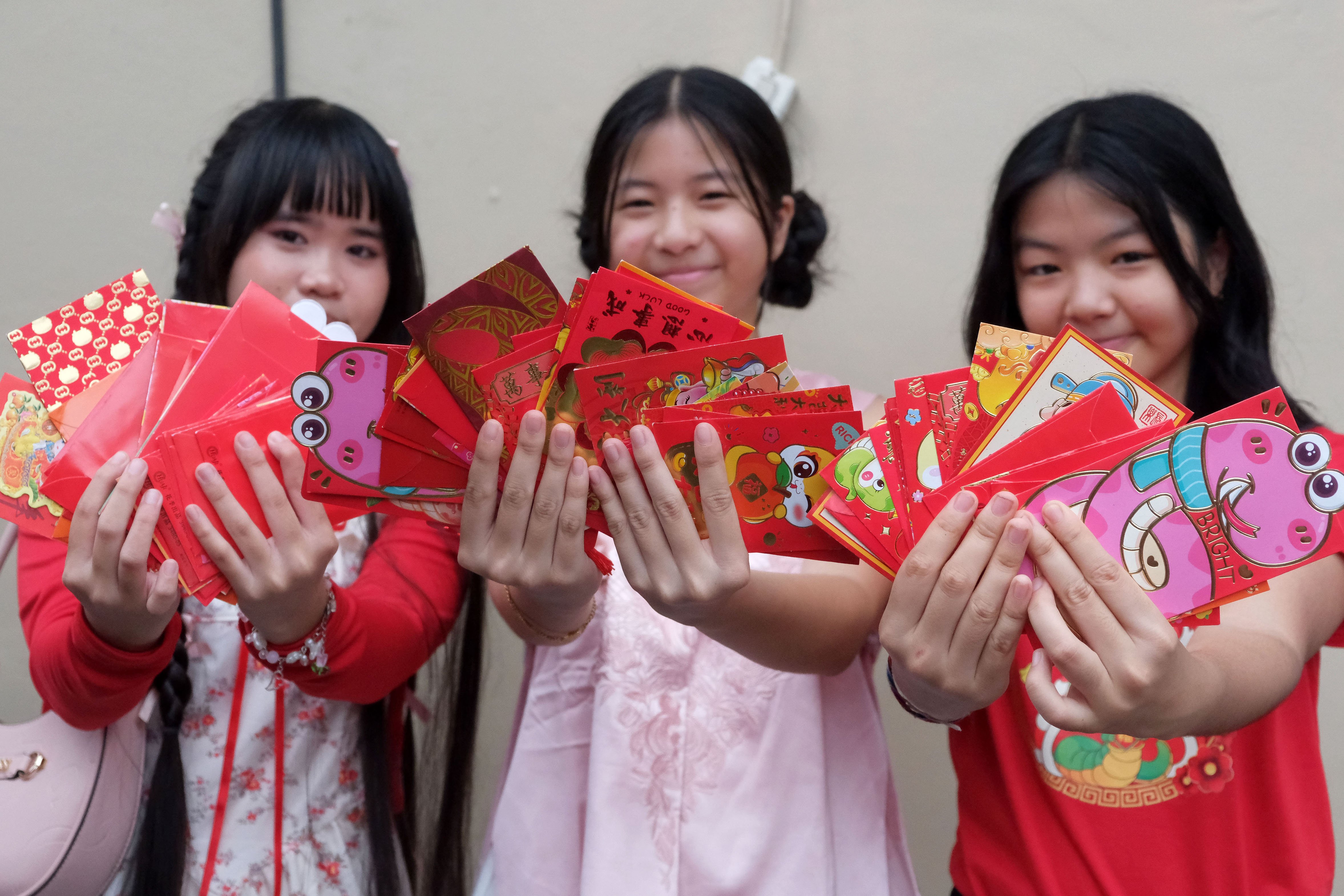 Tiga anak keturunan Tionghoa menunjukkan angpau yang didapat saat tradisi berbagi angpao di Tabanan, Bali, Rabu (29/1/2025). Kegiatan yang digelar keluarga besar marga Kho tersebut merupakan ajang silaturahmi guna mempererat hubungan persaudaraan dan sebagai wujud bakti kepada leluhur dalam perayaan Tahun Baru Imlek 2576 Kongzili. 