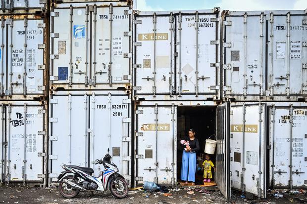 Pengungsi menggendong anaknya di dalam kontainer kosong di Rorotan, Jakarta, Jumat (31/1/2025). Warga Kampung Sepatan, RT 18/05, Rorotan, Cilincing terpaksa mengungsi ke kontainer kosong setelah kediamannya terendam banjir setinggi satu meter.