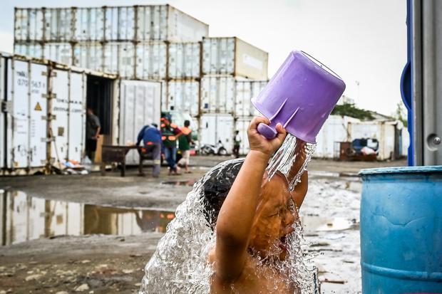 Seorang anak mandi di tempat pengungsian saat rumahnya terendam banjir di Rorotan, Jakarta, Jumat (31/1/2025). Warga Kampung Sepatan, RT 18/05, Rorotan, Cilincing terpaksa mengungsi ke kontainer kosong setelah kediamannya terendam banjir setinggi satu meter.