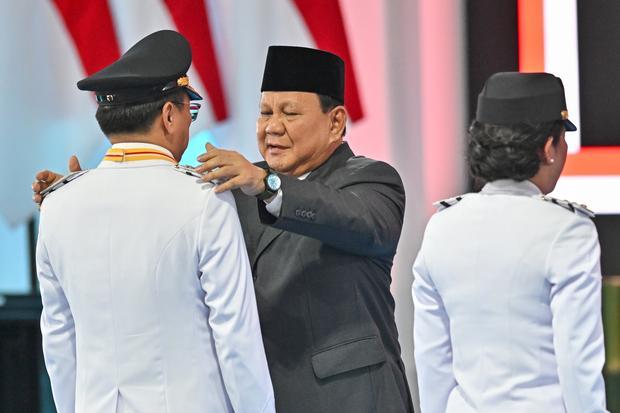 Presiden Prabowo Subianto (tengah) menyematkan tanda pangkat kepada Wali Kota Manado Andrei Angouw (kiri) saat upacara pelantikan di kompleks Istana Kepresidenan, Jakarta, Kamis (20/2/2025). Presiden melantik 961 kepala daerah yang terdiri dari 33 gubernur dan 33 wakil gubernur, 363 bupati, 362 wakil bupati, 85 wali kota, dan 85 wakil wali kota dalam upacara tersebut.