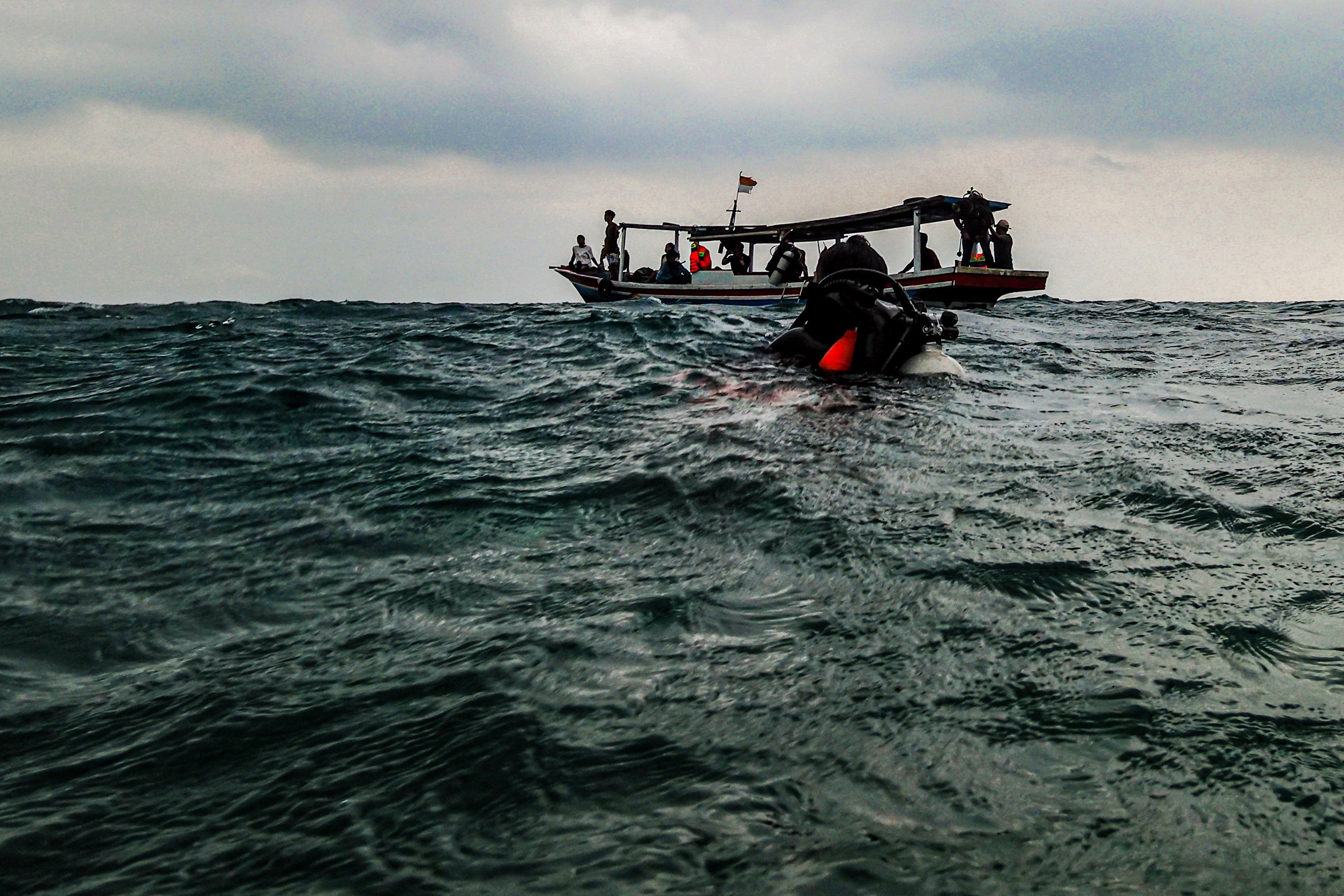 Penyelam bersiap naik ke atas perahu usai melakukan pengecekan terumbu karang di perairan Pulau Tidung, Jakarta.