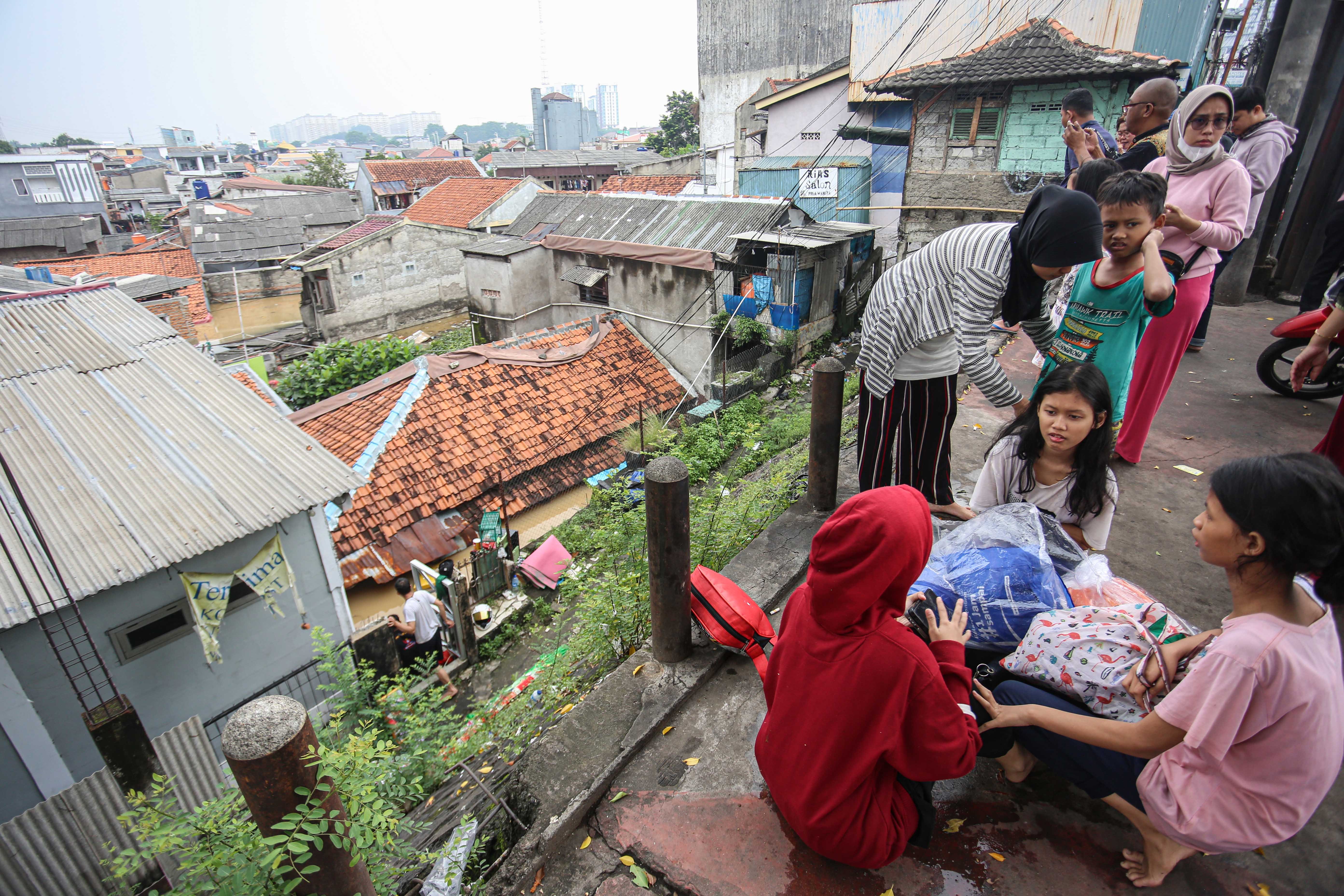 Sejumlah warga mengungsi ke tempat yang lebih tinggi saat banjir merendam wilayah Cililitan, Kramat Jati, Jakarta Timur, Selasa (4/3/2025), Banjir yang merendam wilayah tersebut dengan ketinggian air mulai dari 30 cm hingga 300 cm itu disebabkan oleh meluapnya kali Ciliwung.
