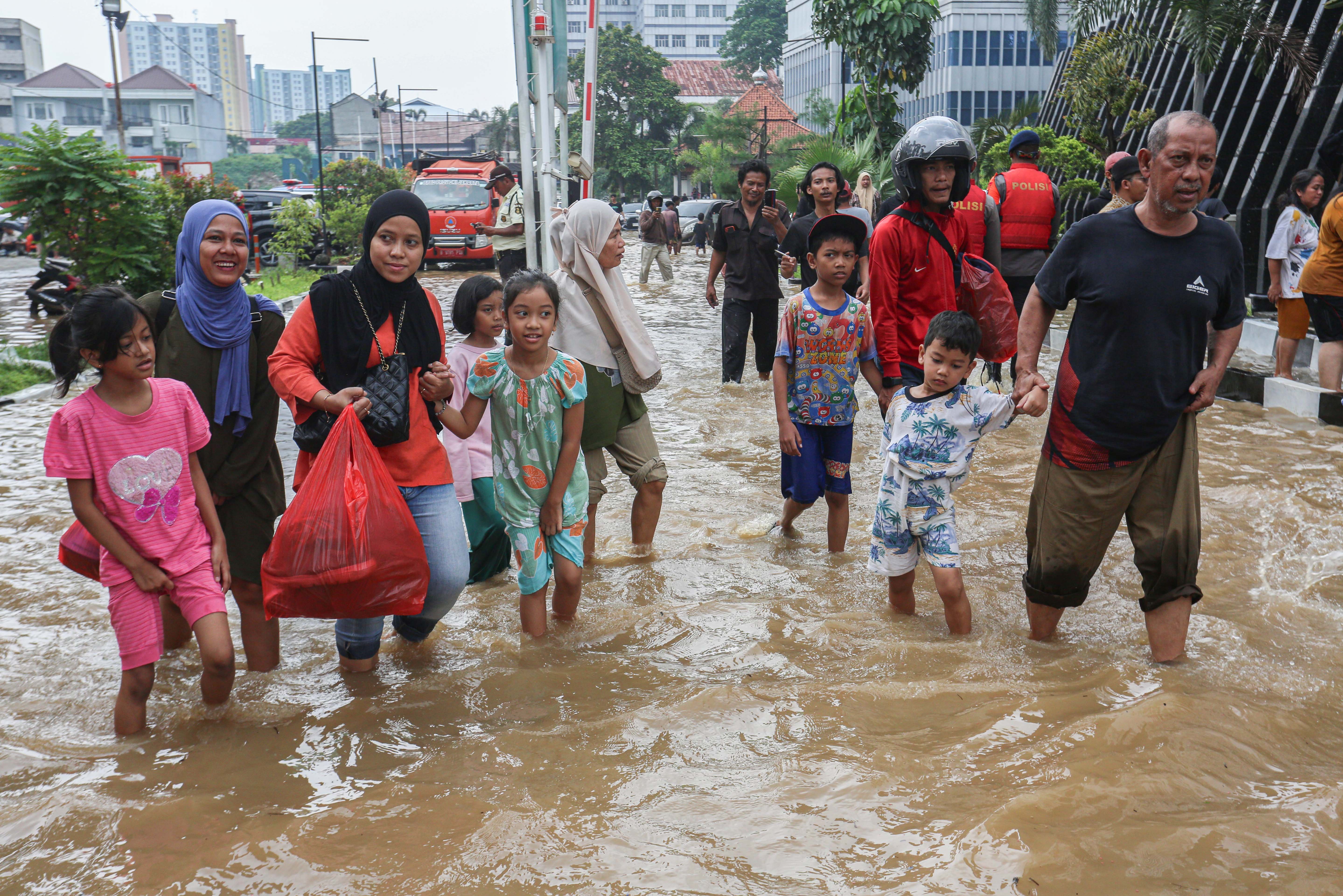 Sejumlah warga melintasi banjir yang merendam wilayah Cililitan, Kramat Jati, Jakarta Timur, Selasa (4/3/2025), Banjir yang merendam wilayah tersebut dengan ketinggian air mulai dari 30 cm hingga 300 cm itu disebabkan oleh meluapnya kali Ciliwung.