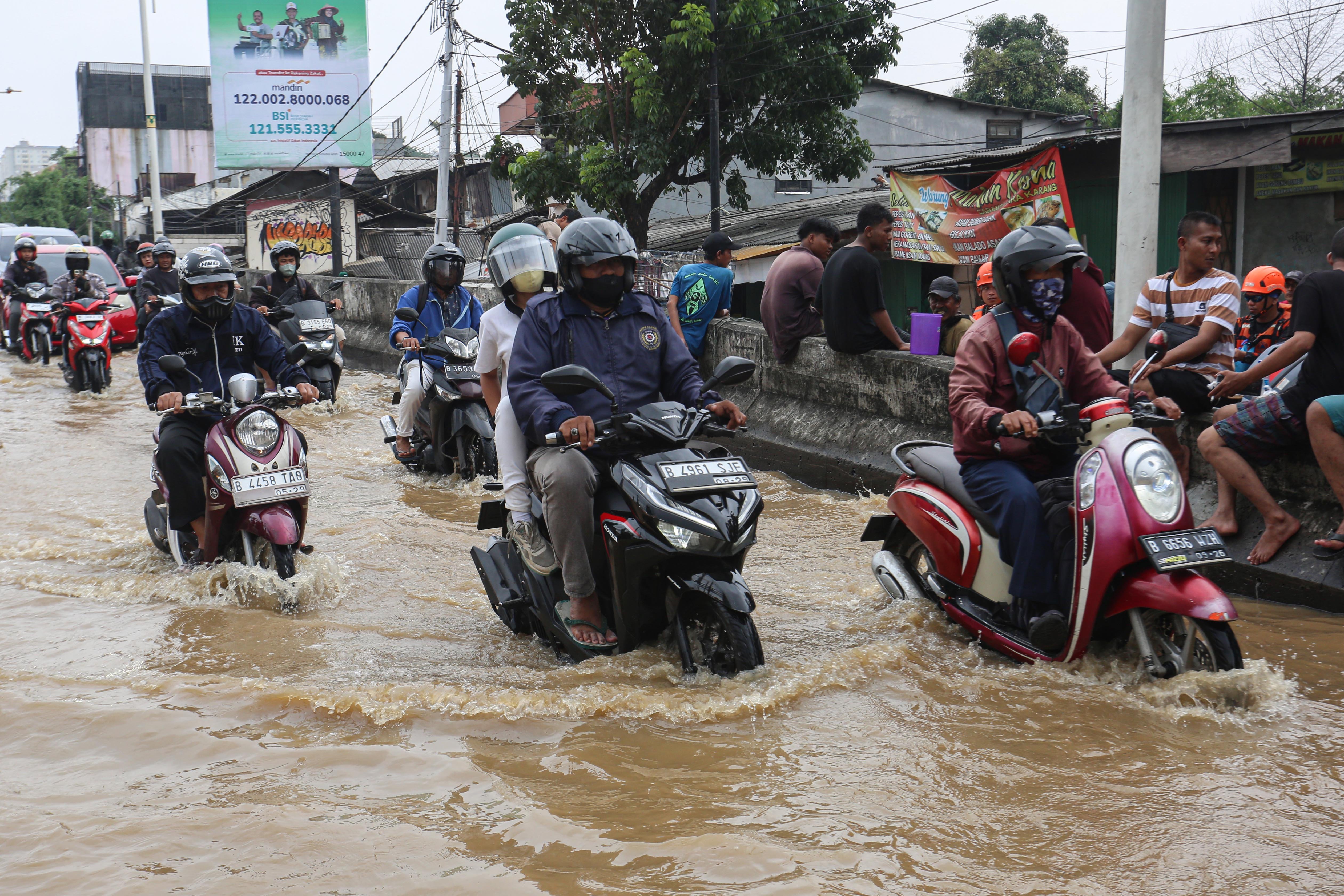Sejumlah pengendara menerobos banjir yang merendam wilayah Cililitan, Kramat Jati, Jakarta Timur, Selasa (4/3/2025), Banjir yang merendam wilayah tersebut dengan ketinggian air mulai dari 30 cm hingga 300 cm itu disebabkan oleh meluapnya kali Ciliwung.