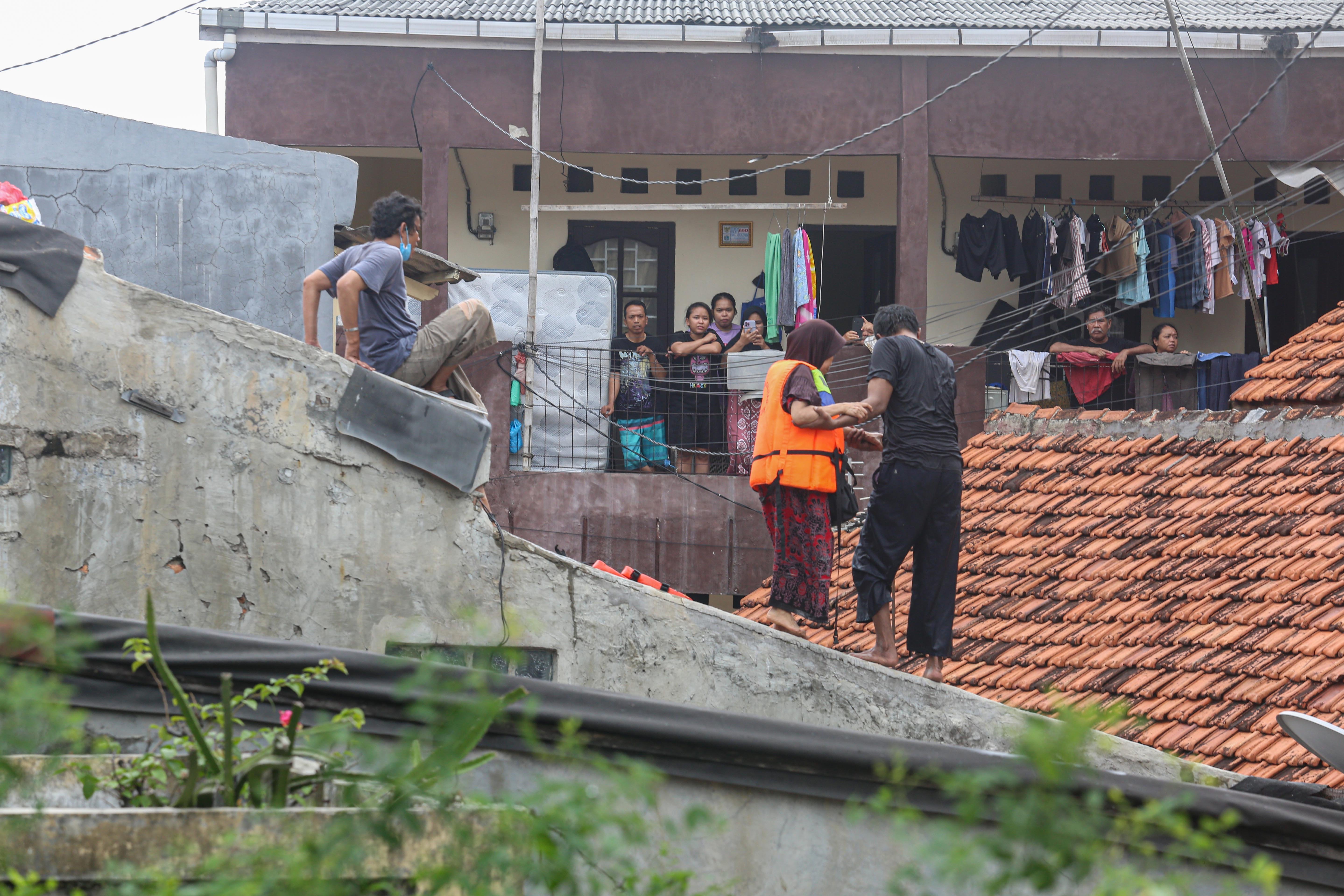 Warga berusaha mengevakuasi orang tuanya saat banjir merendam wilayah Cililitan, Kramat Jati, Jakarta Timur, Selasa (4/3/2025), Banjir yang merendam wilayah tersebut dengan ketinggian air mulai dari 30 cm hingga 300 cm itu disebabkan oleh meluapnya kali Ciliwung.