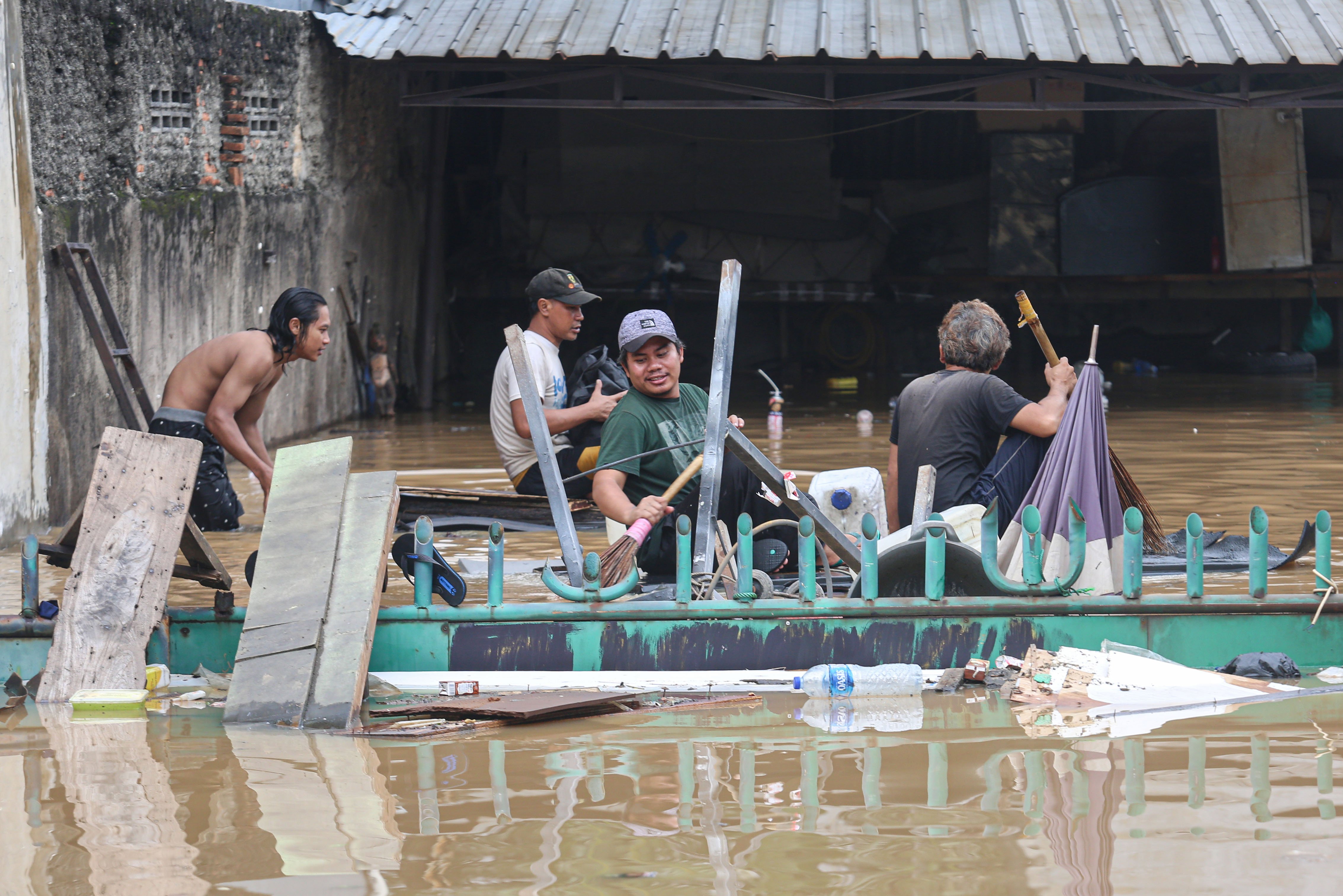 Sejumlah warga meninggalkan rumahnya yang terendam banjir di wilayah Cililitan, Kramat Jati, Jakarta Timur, Selasa (4/3/2025), Banjir yang merendam wilayah tersebut dengan ketinggian air mulai dari 30 cm hingga 300 cm itu disebabkan oleh meluapnya kali Ciliwung.