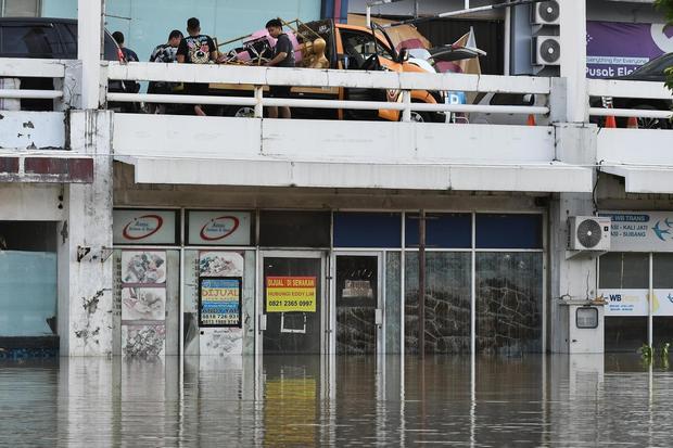 Pedagang memindahkan barang dagangan yang terendam banjir luapan Kali Bekasi di pusat perbelanjaan Marga Jaya, Bekasi, Jawa Barat, Rabu (5/3/2025). Menurut pengelola pusat perbelanjaan sebanyak 600 tenant terdampak luapan Kali Bekasi dan lantai bawah masih tergenang air dengan ketinggian 1-2 meter.