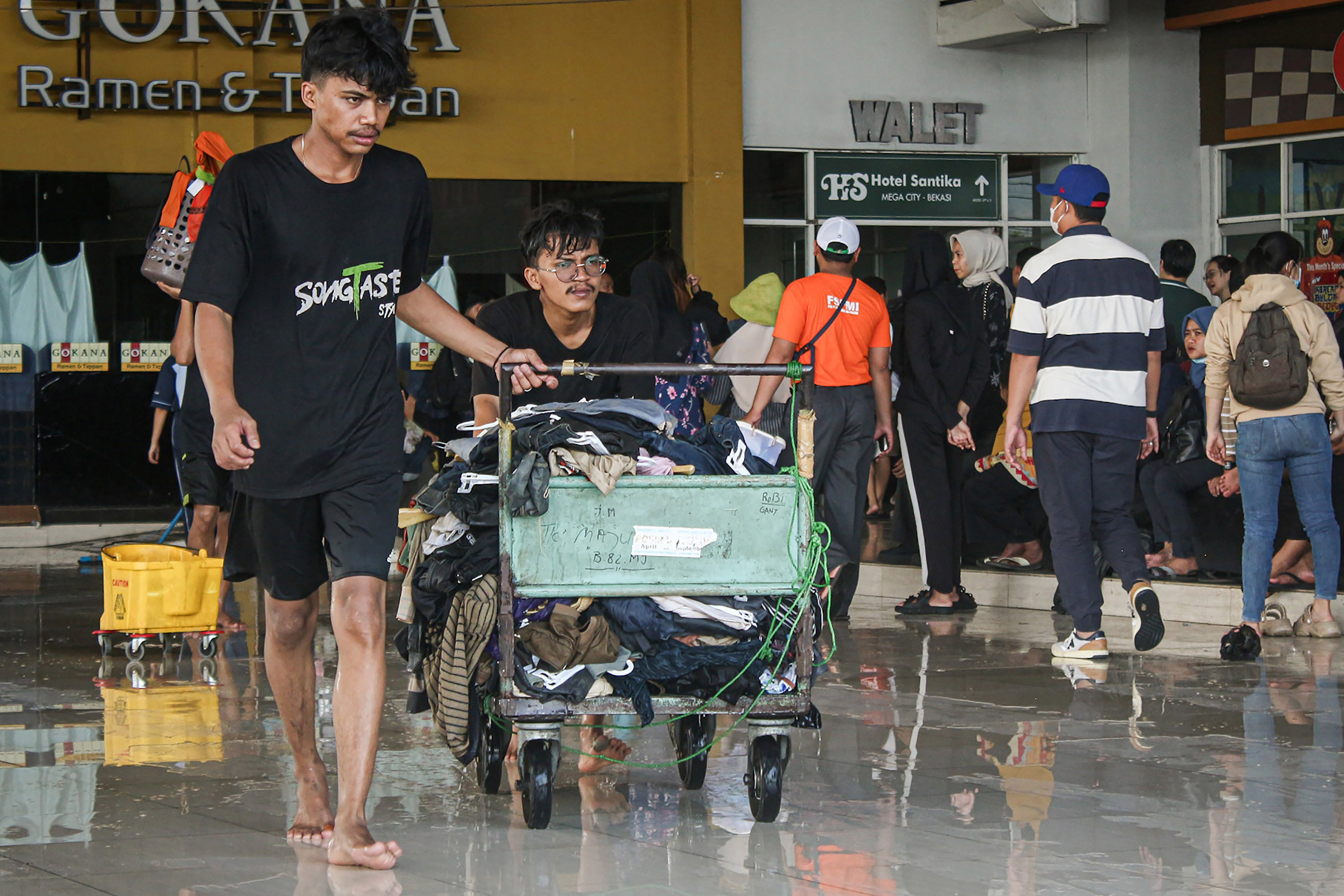 Pedagang memindahkan barang dagangannya yang terendam banjir di Mega Mal Bekasi, Bekasi, Jawa Barat, Rabu (5/3/2025). Pedagang di pusat perbelanjaan tersebut mulai memindahkan dan mengamankan barang dagangannya yang masih bisa diselamatkan akibat terendam banjir. 