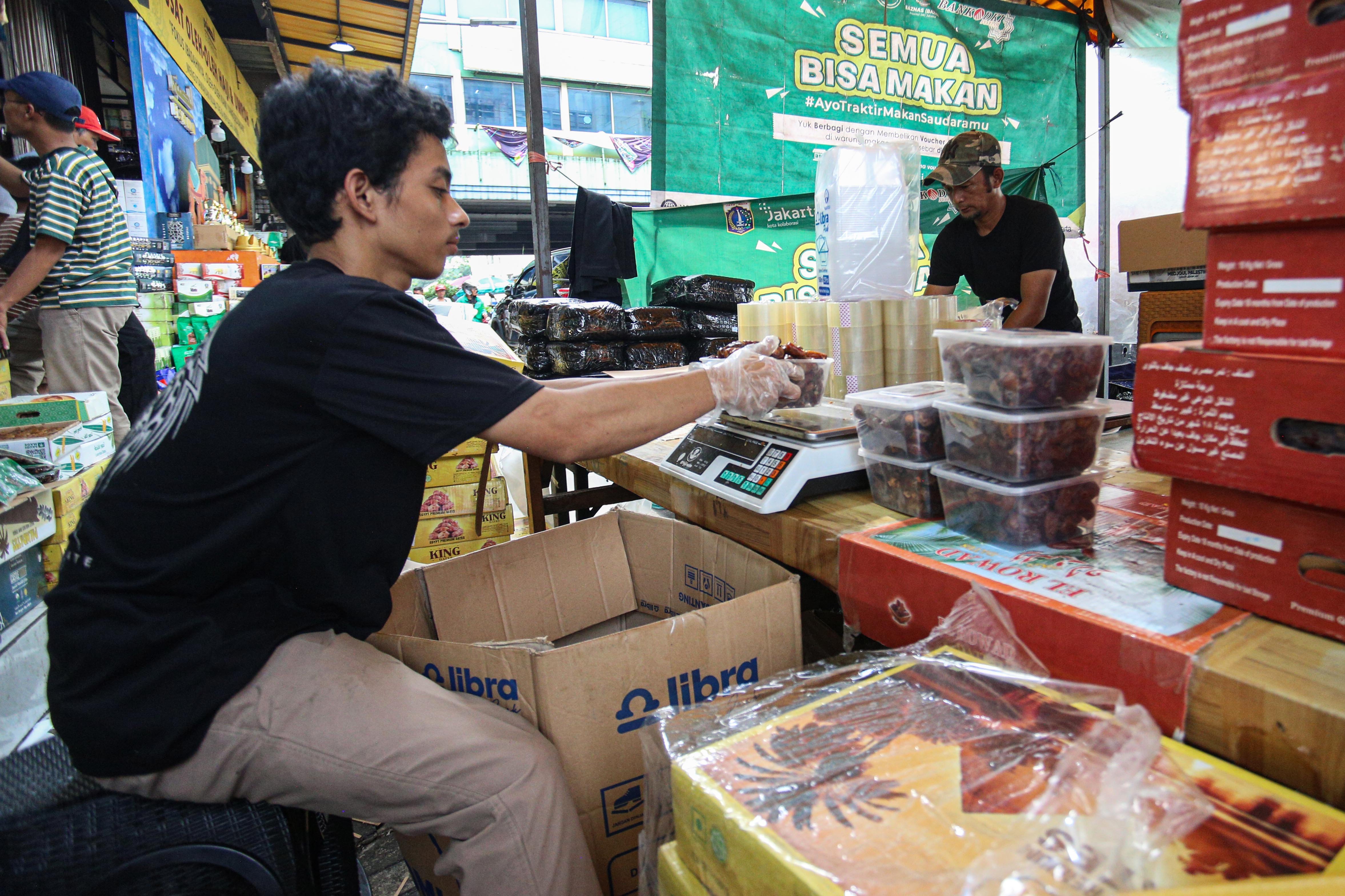 Pedagang mengemas kurma pesanan konsumen di Blok C Pasar Tanah Abang, Jakarta, Kamis (6/3/2025). Berdasarkan penuturan pedagang, penjualan kurma di bulan Ramadhan mengalami peningkatan hingga 70 persen dengan total pesanan mencapai 7000 kemasan per harinya.