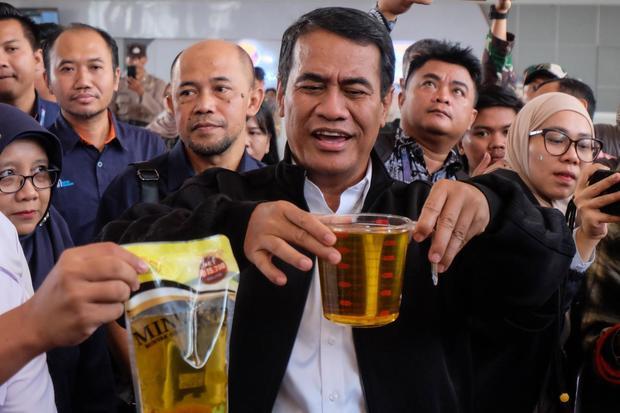 Menteri Pertanian Amran Sulaiman (tengah) menunjukkan takaran Minyakita kemasan saat meninjau program PosAgri Operasi Pasar Ramadhan di Kantor Pos Solo, Jawa Tengah, Selasa (11/3/2025). Kunjungan kerja tersebut untuk meninjau pelaksanaan Operasi Pasar Ramadhan di Solo guna menjamin tidak akan ada kekurangan stok kebutuhan pokok serta harga di atas harga eceran tertinggi (HET).