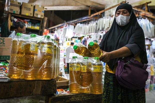 Calon pembeli menata Minyakita di Pasar Tebet Barat, Jakarta, Selasa (11/3/2025). Kementerian Perdagangan mulai menarik produk minyak goreng bersubsidi merek Minyakita yang volumenya tidak sesuai takaran satu liter atau hanya berisi sekitar 750-800 mililiter di pasaran agar tidak semakin merugikan masyarakat.