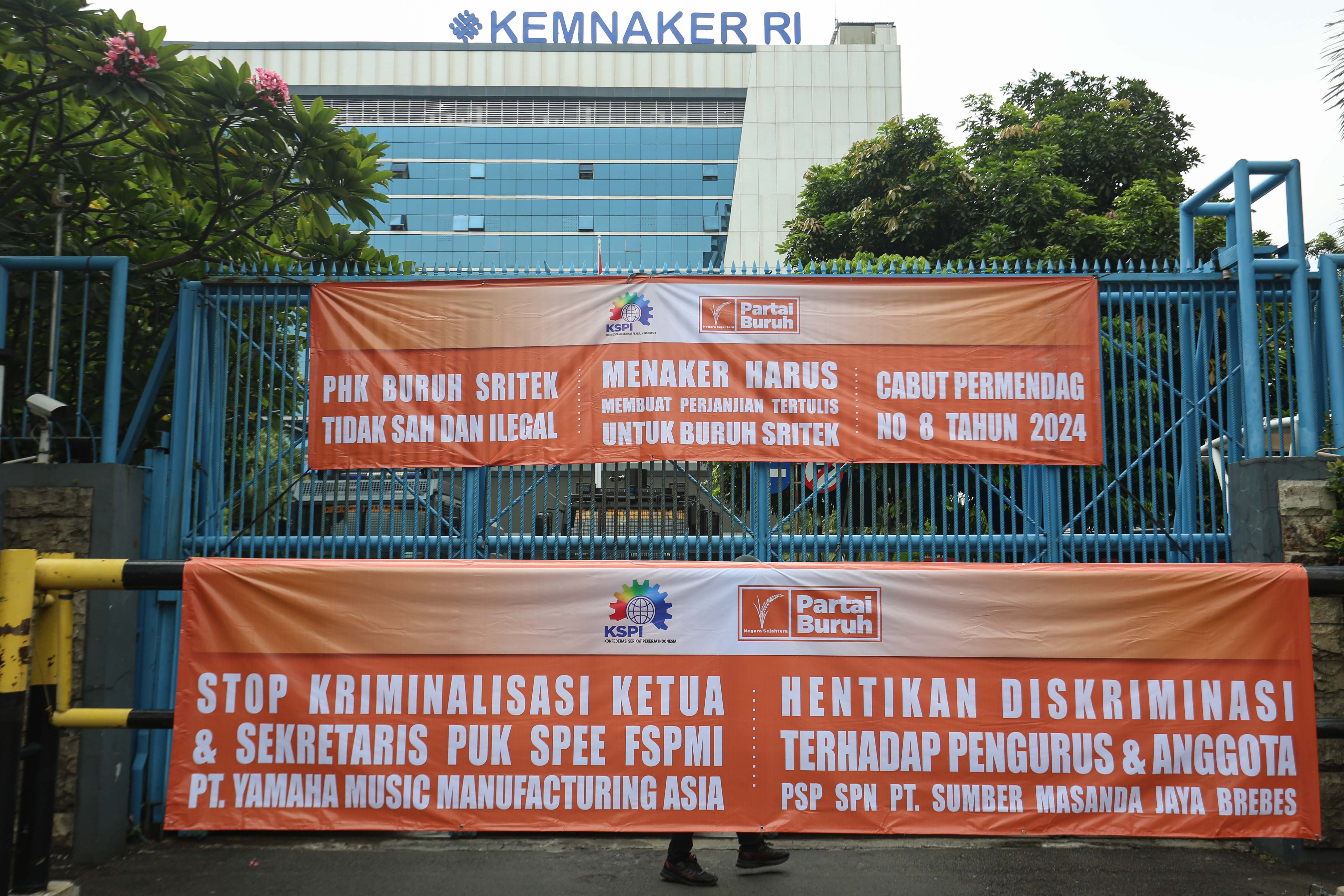 Spanduk tuntutan dari buruh saat aksi unjuk rasa di depan kantor Kementerian Ketenagakerjaan, Jakarta, Selasa (11/3/2025). Dalam aksinya tersebut mereka menyampaikan beberapa tuntutan salah satunya yakni stop badai pemutusan hubungan kerja (PHK) dan selamatkan industri Indonesia. 