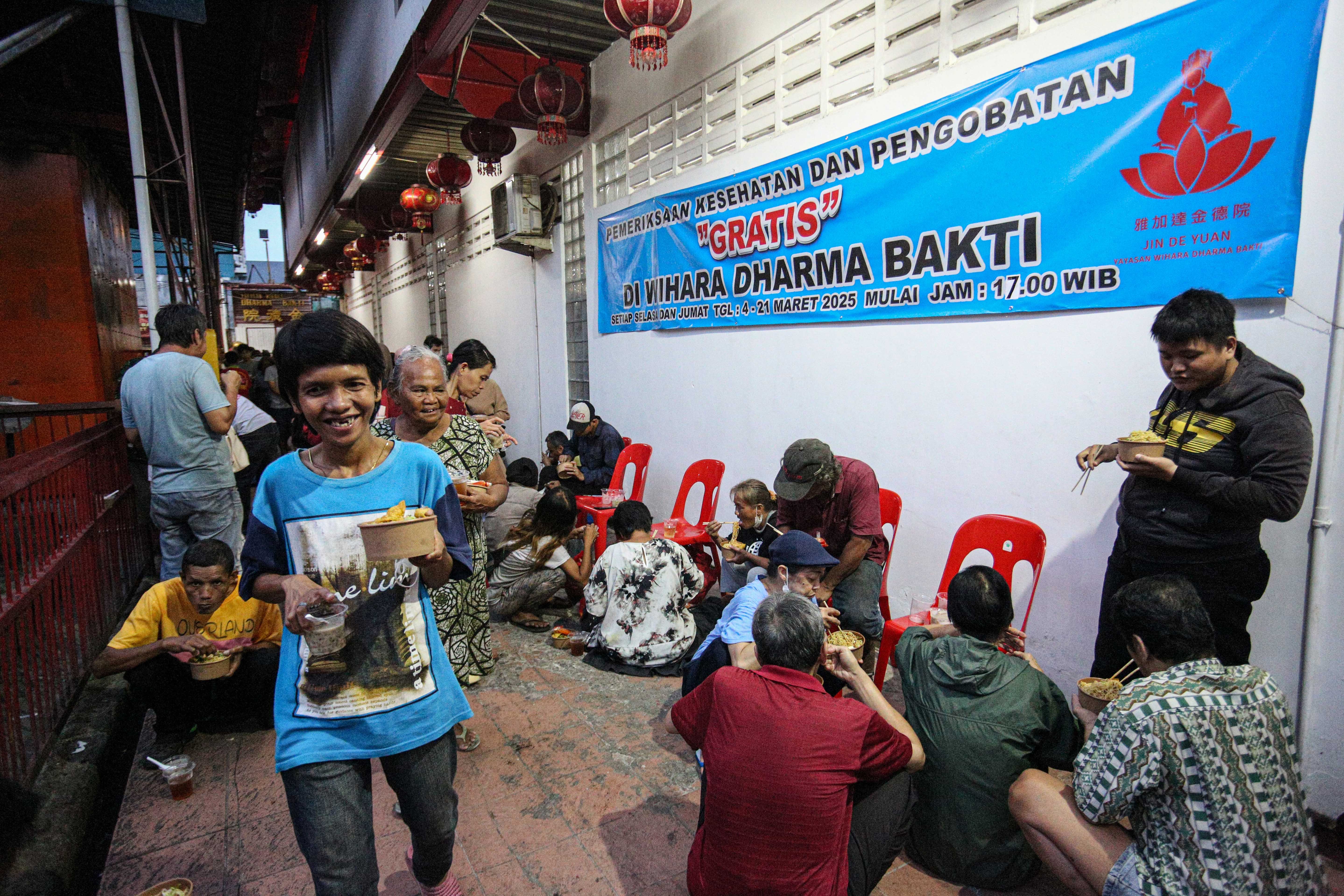 Warga membawa makanan yang telah dibagikan pada acara buka bersama di Vihara Dharma Bakti, Petak Sembilan, Glodok, Jakarta Barat, Senin (10/3/2025). Kegiatan yang digelar sebagai bentuk toleransi antar umat beragama dengan membagikan 350 porsi makanan buka puasa bagi umat muslim tersebut berlangsung hingga 24 Maret 2025. 