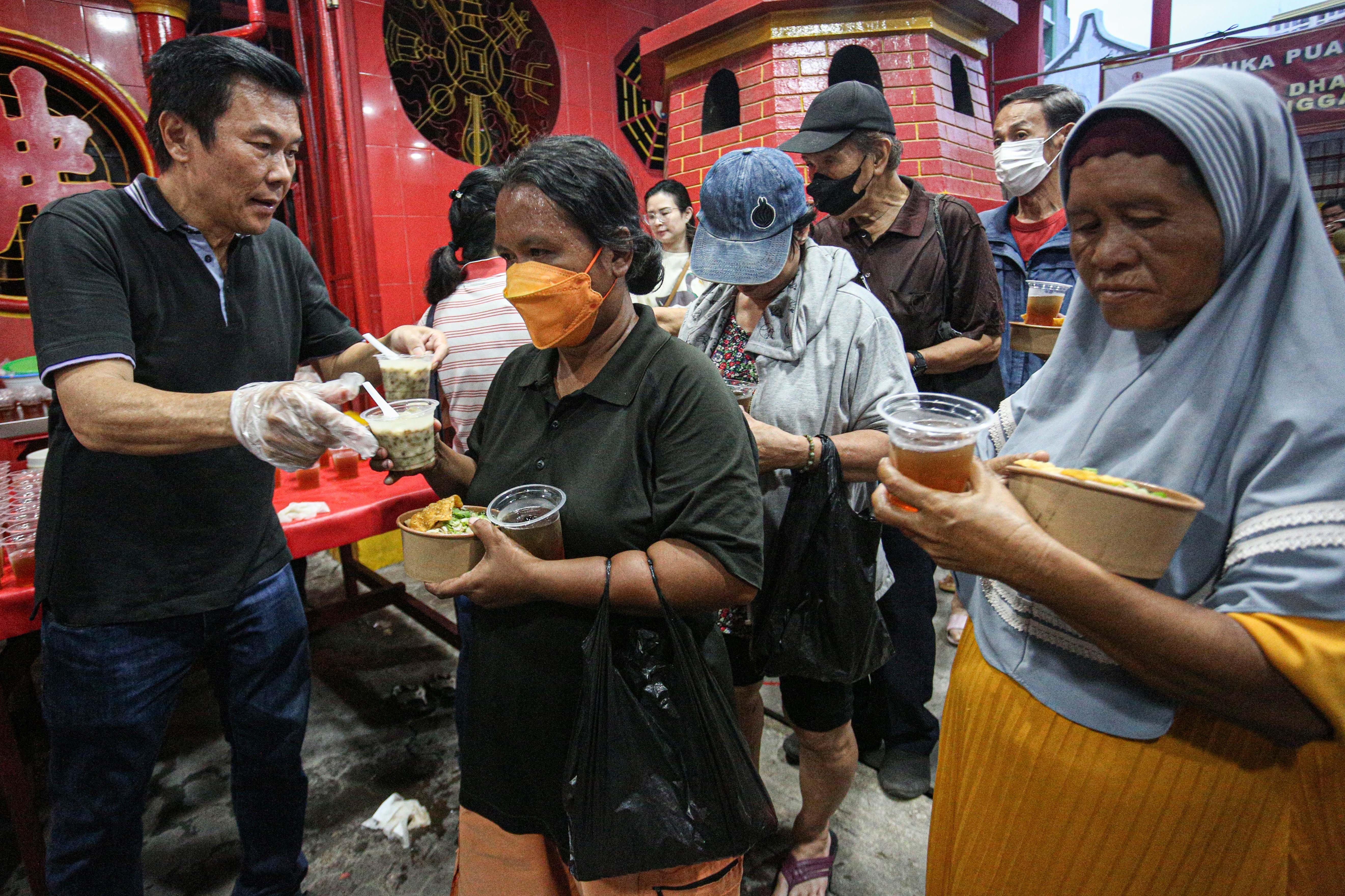 Panitia membagikan makanan kepada warga pada acara buka bersama di Vihara Dharma Bakti, Petak Sembilan, Glodok, Jakarta Barat, Senin (10/3/2025). Kegiatan yang digelar sebagai bentuk toleransi antar umat beragama dengan membagikan 350 porsi makanan buka puasa bagi umat muslim tersebut berlangsung hingga 24 Maret 2025. 