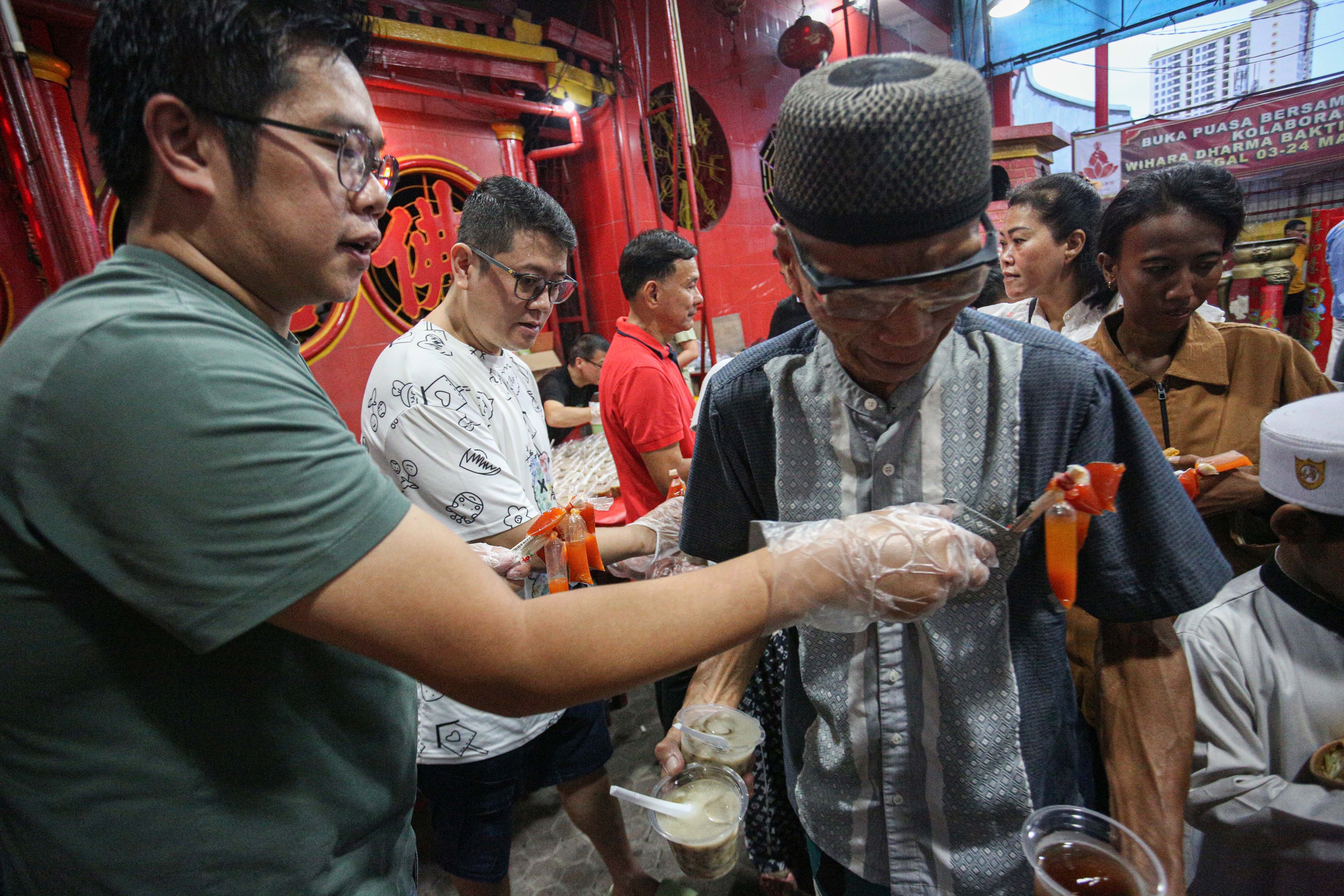 Panitia membagikan makanan kepada warga pada acara buka bersama di Vihara Dharma Bakti, Petak Sembilan, Glodok, Jakarta Barat, Senin (10/3/2025). Kegiatan yang digelar sebagai bentuk toleransi antar umat beragama dengan membagikan 350 porsi makanan buka puasa bagi umat muslim tersebut berlangsung hingga 24 Maret 2025. 