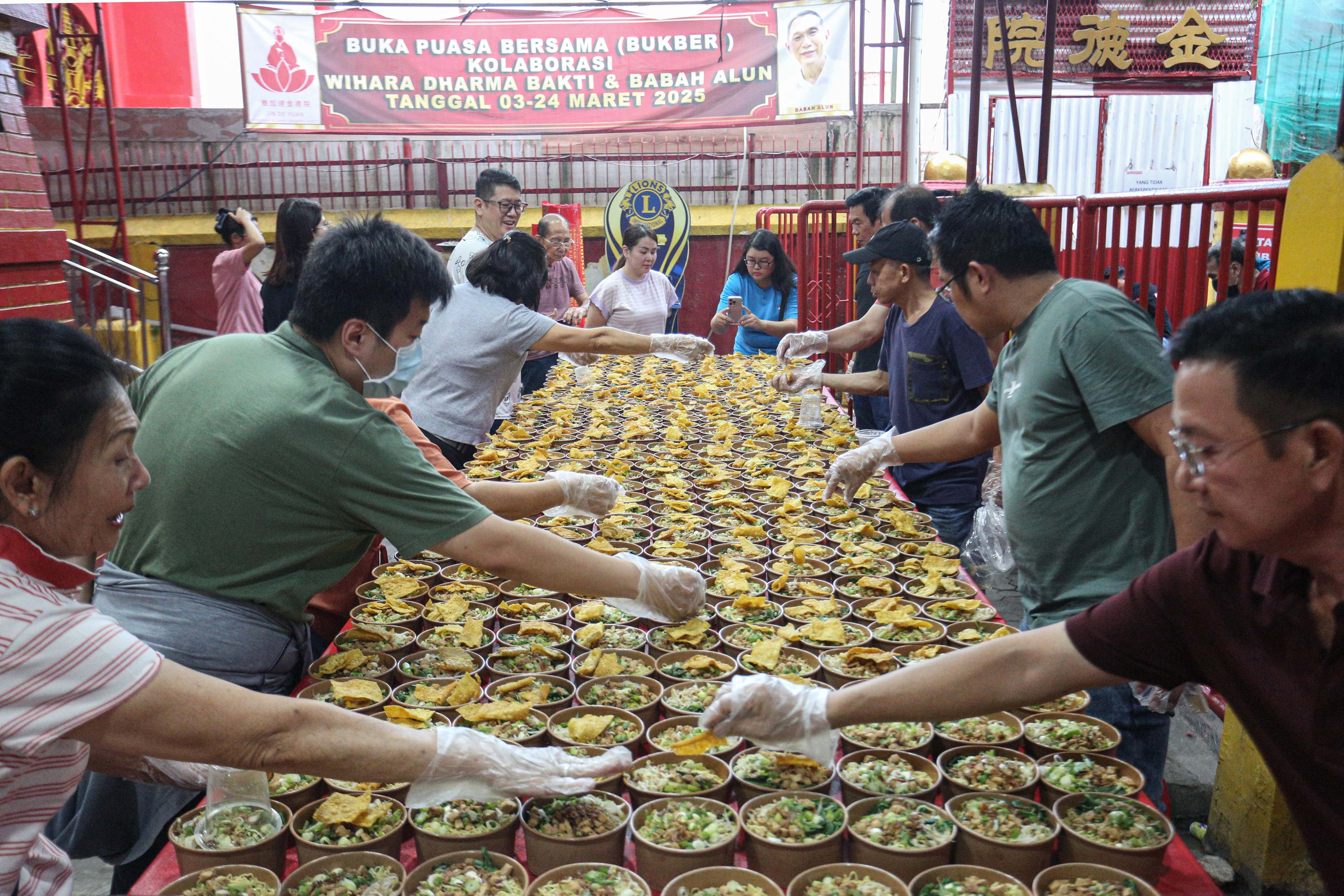 Panitia menyiapkan makanan pada acara buka bersama di Vihara Dharma Bakti, Petak Sembilan, Glodok, Jakarta Barat, Senin (10/3/2025). Kegiatan yang digelar sebagai bentuk toleransi antar umat beragama dengan membagikan 350 porsi makanan buka puasa bagi umat muslim tersebut berlangsung hingga 24 Maret 2025. 