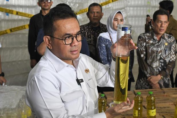 Menteri Perdagangan Budi Santoso (tengah) menunjukkan takaran Minyakita 1 liter yang dikurangi PT Artha Eka Global Asia di Kabupaten Karawang, Jawa Barat, Kamis (13/5/2025). Dari hasil ekspose Kementerian Perdagangan menemukan pelanggaran aturan ketentuan takaran Minyakita dari 1000 ml atau 1 liter menjadi 800 ml dan menyita 140 dus Minyakita serta 32.284 botol yang siap diisi.