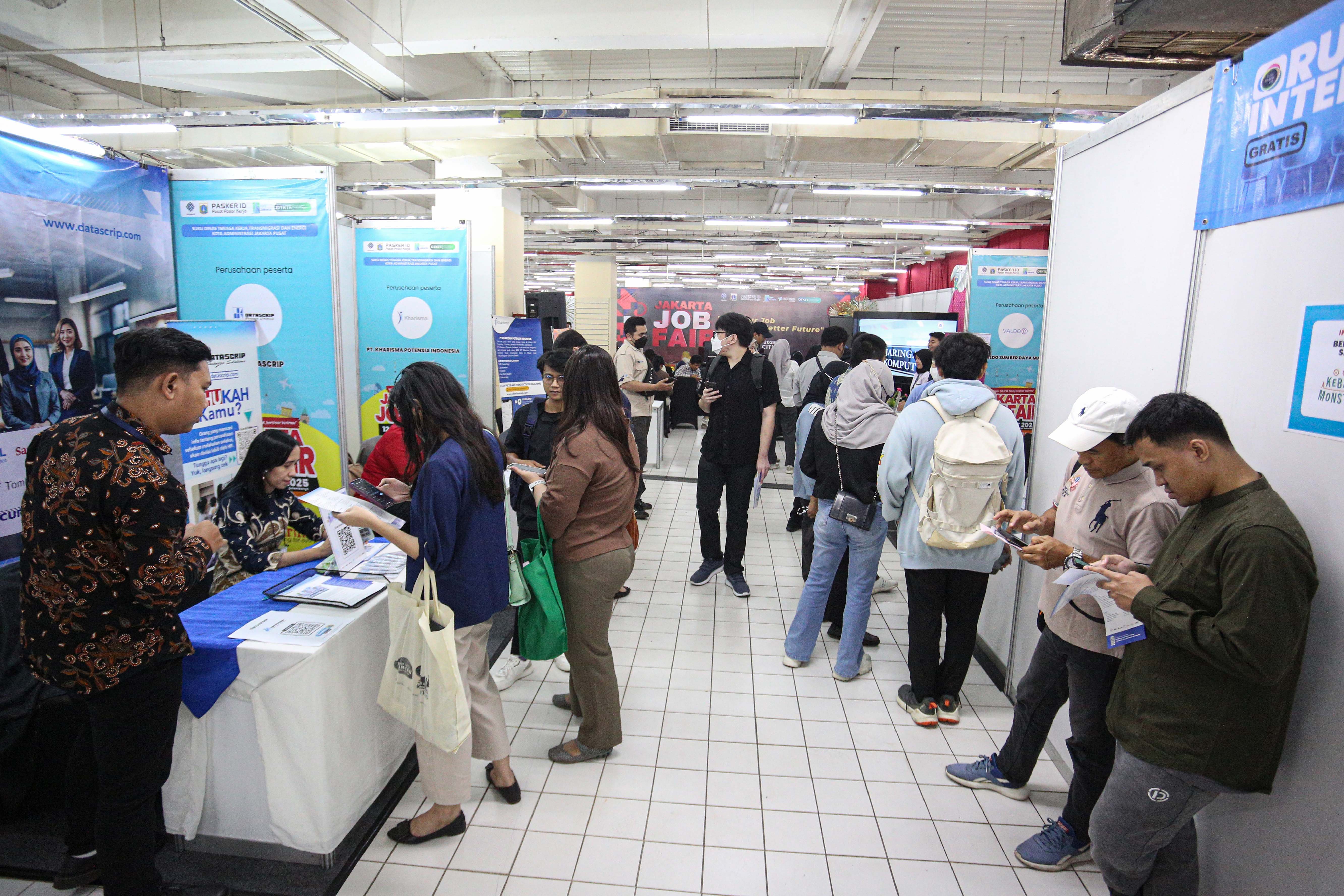 Pencari kerja melihat informasi lowongan kerja yang tersedia saat berlangsungnya bursa kerja di Mal Thamrin City, Jakarta Pusat, Rabu (12/3/2025). Bursa kerja yang digelar oleh Suku Dinas Tenaga Kerja, Transmigrasi dan Energi Jakarta Pusat tersebut diikuti oleh 40 perusahaan yang menawarkan sebanyak 2.708 lowongan pekerjaan. 