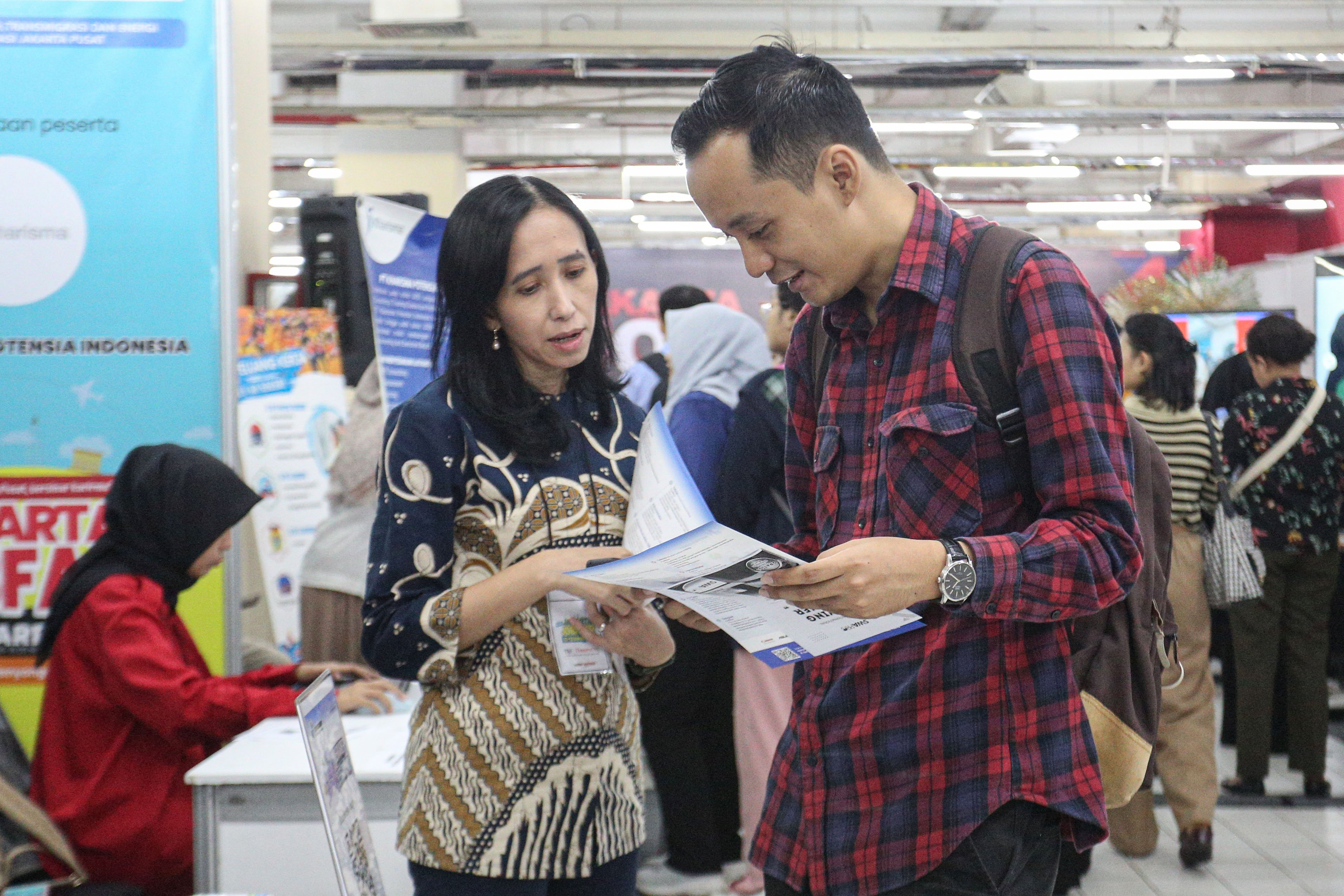 Petugas memberikan informasi terkait lowongan kerja yang tersedia kepada pencari kerja saat berlangsungnya bursa kerja di Mal Thamrin City, Jakarta Pusat, Rabu (12/3/2025). Bursa kerja yang digelar oleh Suku Dinas Tenaga Kerja, Transmigrasi dan Energi Jakarta Pusat tersebut diikuti oleh 40 perusahaan yang menawarkan sebanyak 2.708 lowongan pekerjaan. 