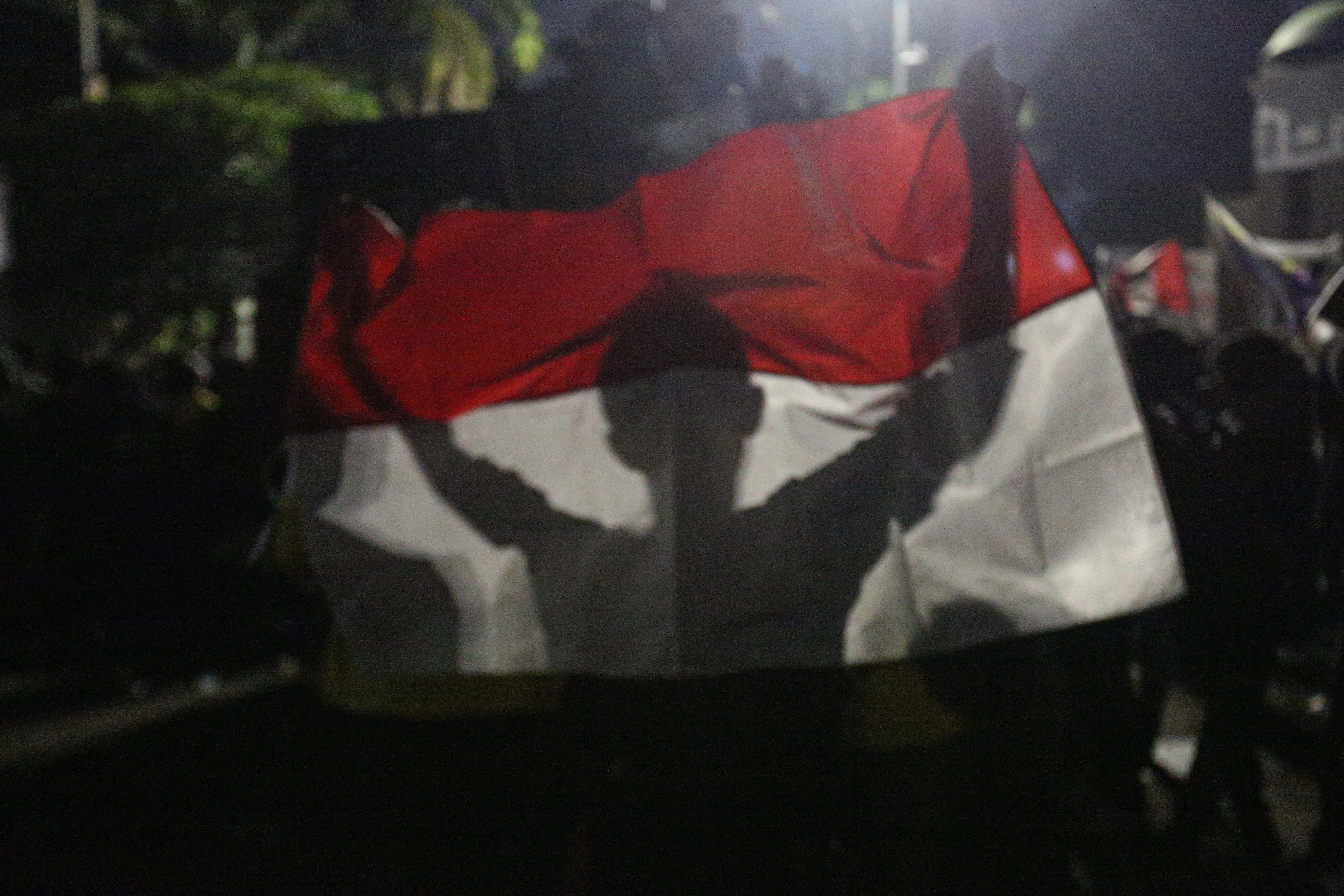 Pengunjuk rasa membentangkan bendera Merah Putih saat menggelar aksi demonstrasi terkait Revisi Undang-Undang TNI di depan gedung DPR, Senayan, Jakarta, Kamis (20/3/2025). Unjuk rasa yang diikuti oleh mahasiswa dan koalisi masyarakat sipil tersebut menolak pengesahan RUU TNI yang dinilai dapat mengembalikan dwifungsi TNI seperti era Orde Baru.