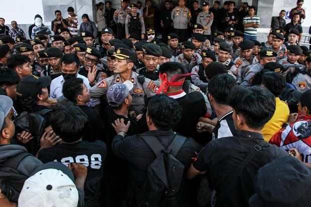 Sejumlah pengunjuk rasa terlibat saling dorong dengan aparat saat aksi menyikapi UU TNI di depan kantor DPRD Kalimantan Tengah, Palangka Raya, Senin (24/3/2025).