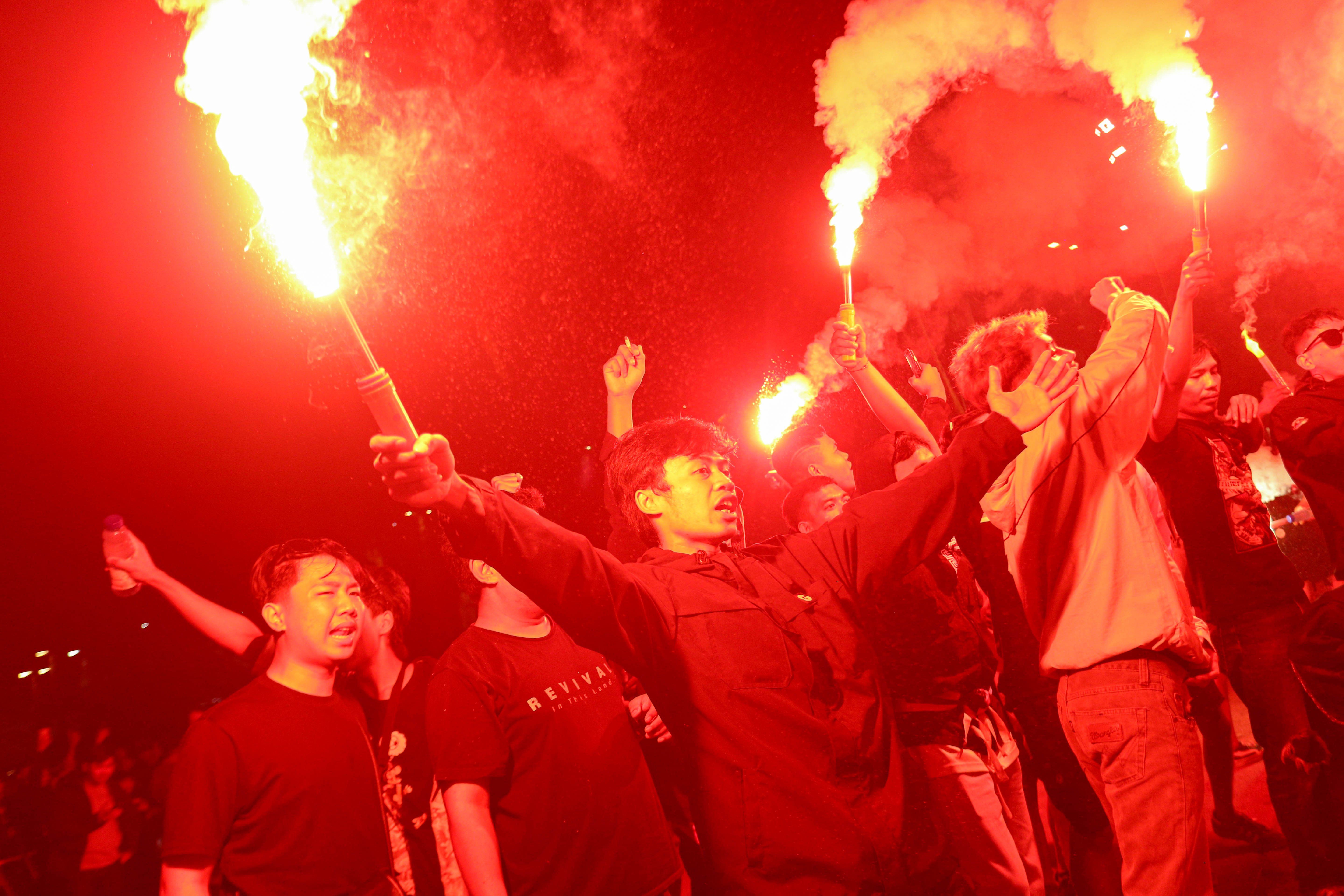 Suporter menyalakan suar dan meneriakkan yel-yel jelang laga Timnas Indonesia melawan Bahrain di luar area Stadion Utama Gelora Bung Karno, Senayan, Jakarta, Selasa (25/3/2025). Dukungan tersebut ditujukan bagi Timnas Indonesia yang akan berlaga kontra Bahrain dalam putaran ketiga Kualifikasi Piala Dunia 2026 Zona Asia.