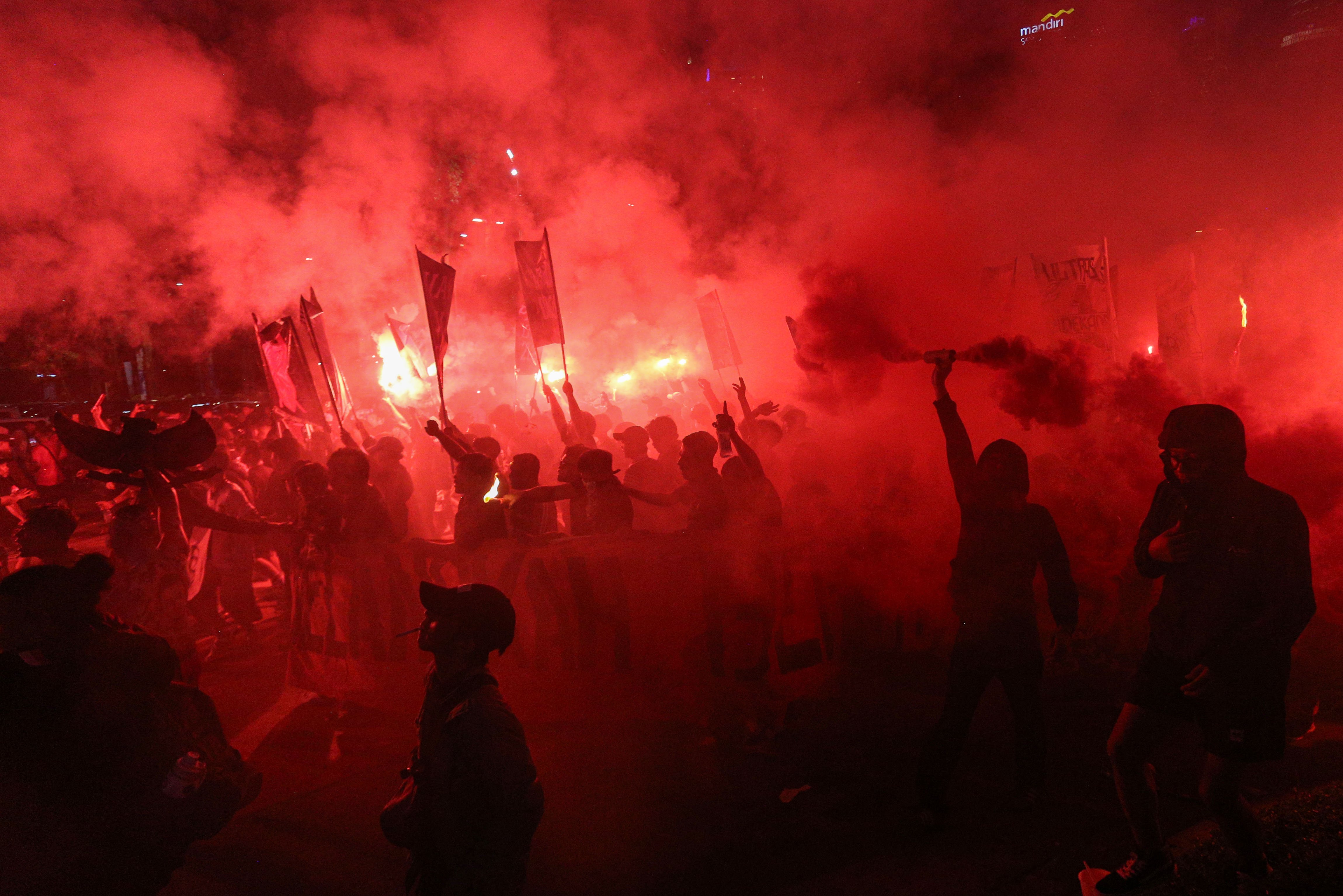 Suporter menyalakan suar jelang laga Timnas Indonesia melawan Bahrain di luar area Stadion Utama Gelora Bung Karno, Senayan, Jakarta, Selasa (25/3/2025). Dukungan tersebut ditujukan bagi Timnas Indonesia yang akan berlaga kontra Bahrain dalam putaran ketiga Kualifikasi Piala Dunia 2026 Zona Asia.